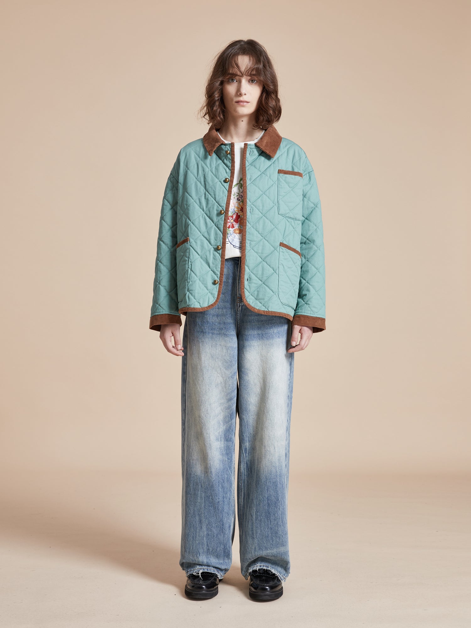A woman wearing a Found Kashmir Meadow Quilt Jacket and jeans.