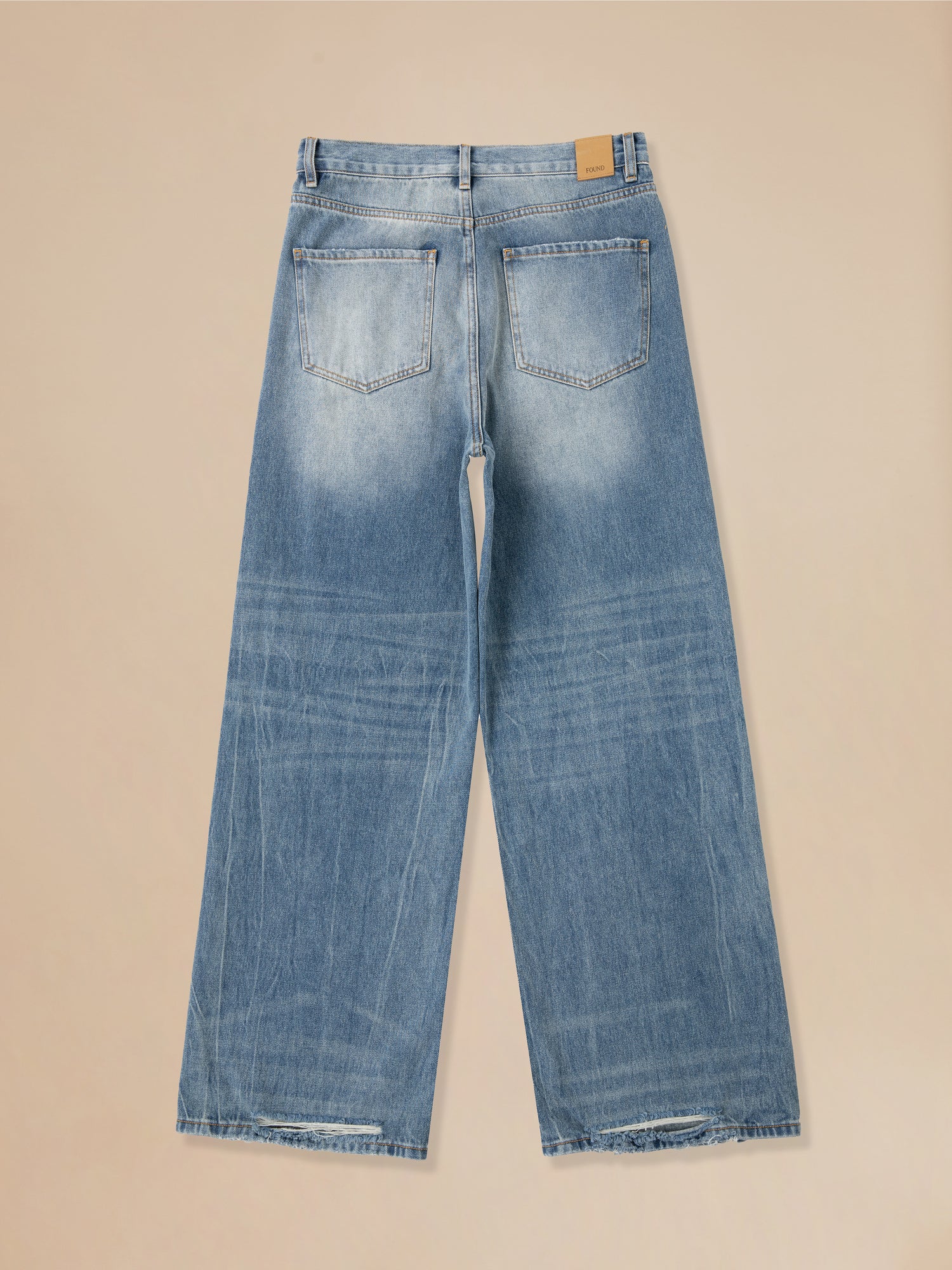 A pair of Found Lacy Baggy Jeans Blue with holes on the side.