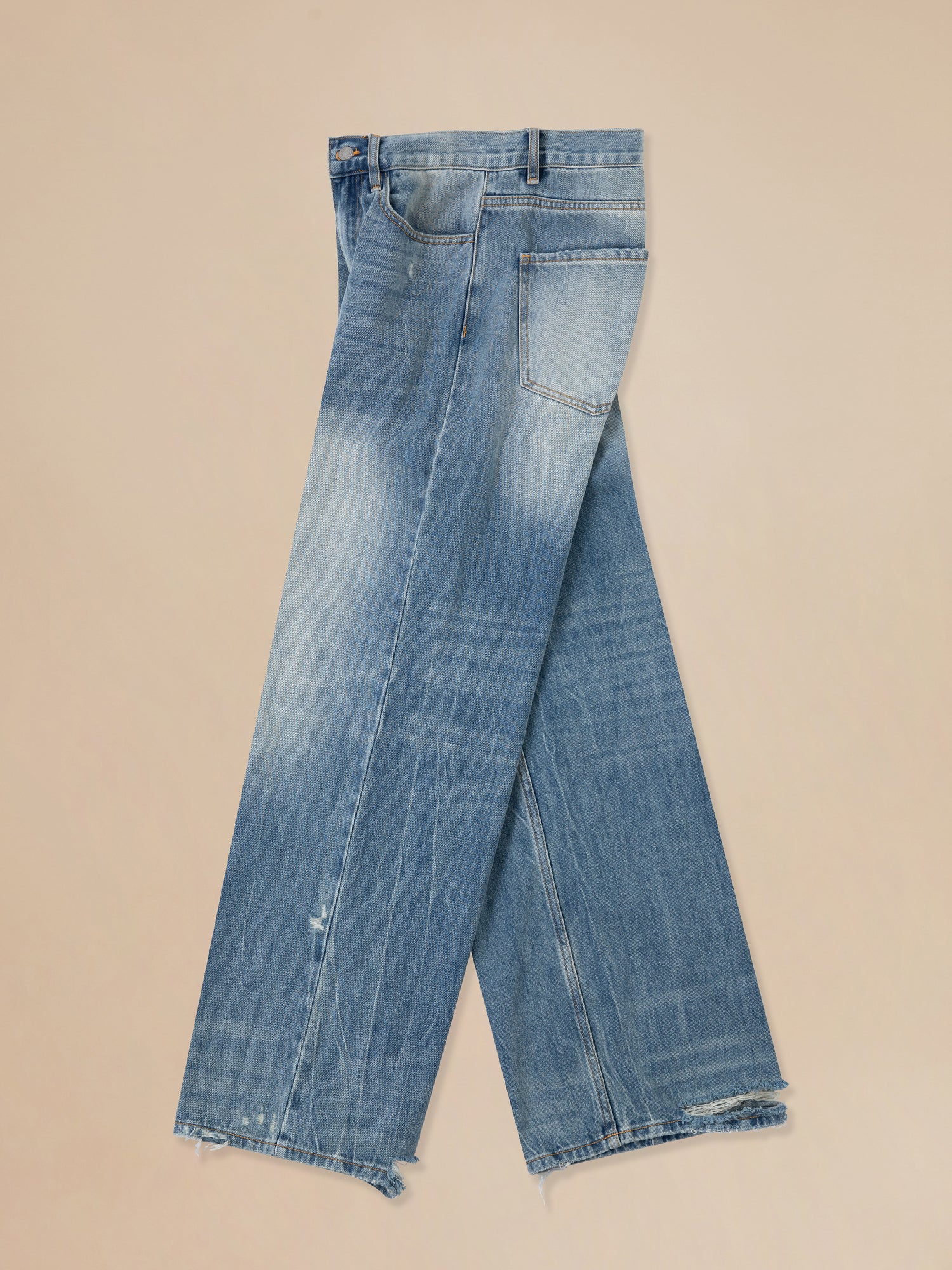 A pair of Found Lacy Baggy Jeans Blue with frayed edges.