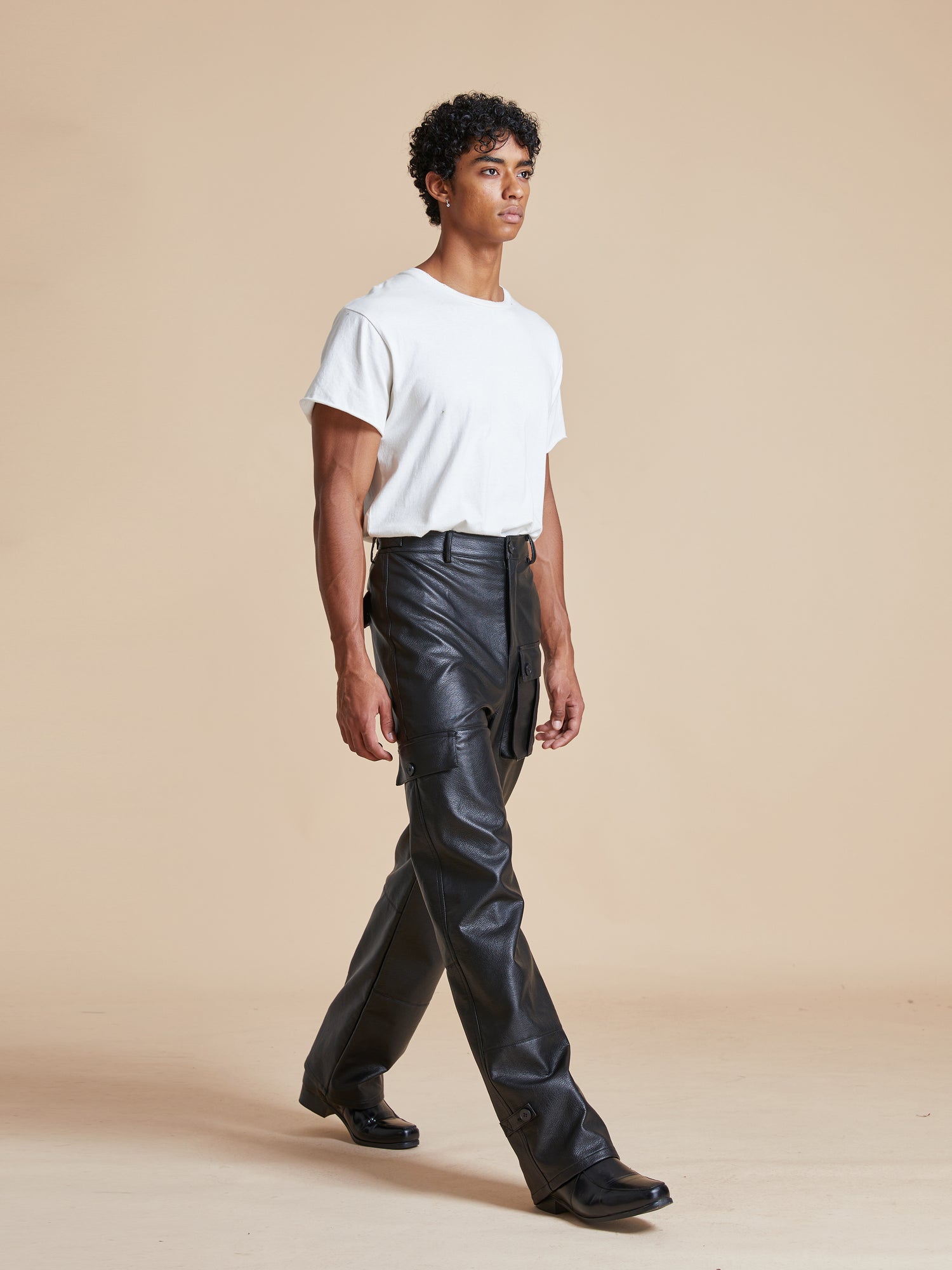 A man wearing Found Faux Leather Cargo Pants and a white t-shirt.
