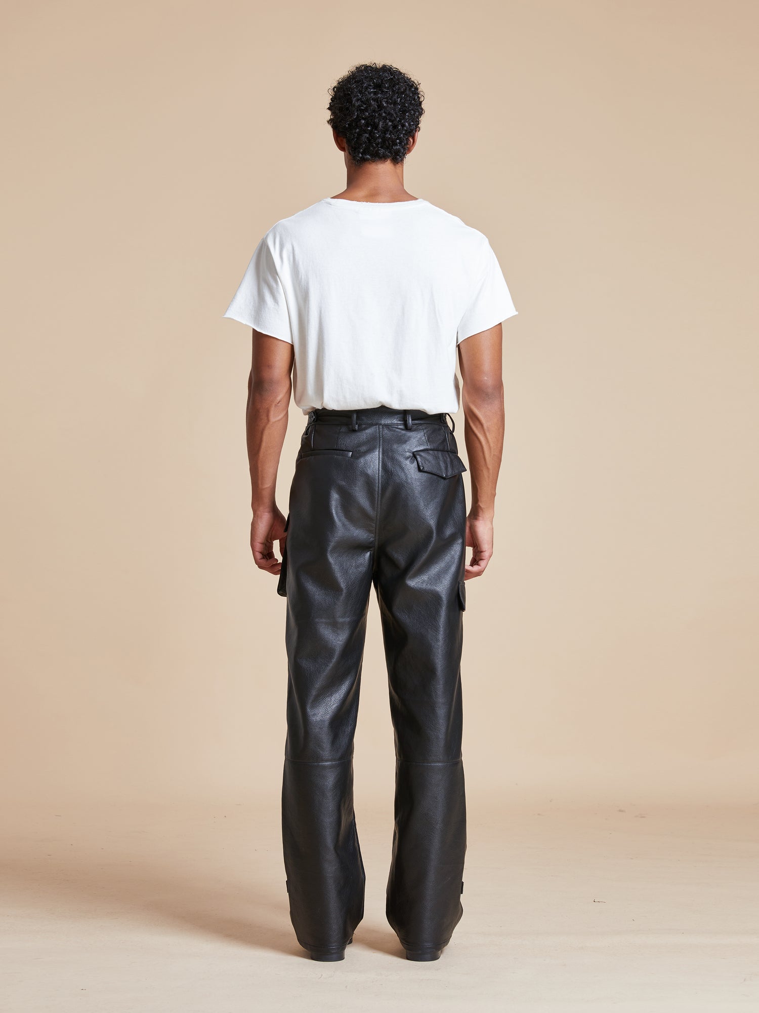 The back view of a man wearing Found Faux Leather Cargo Pants.