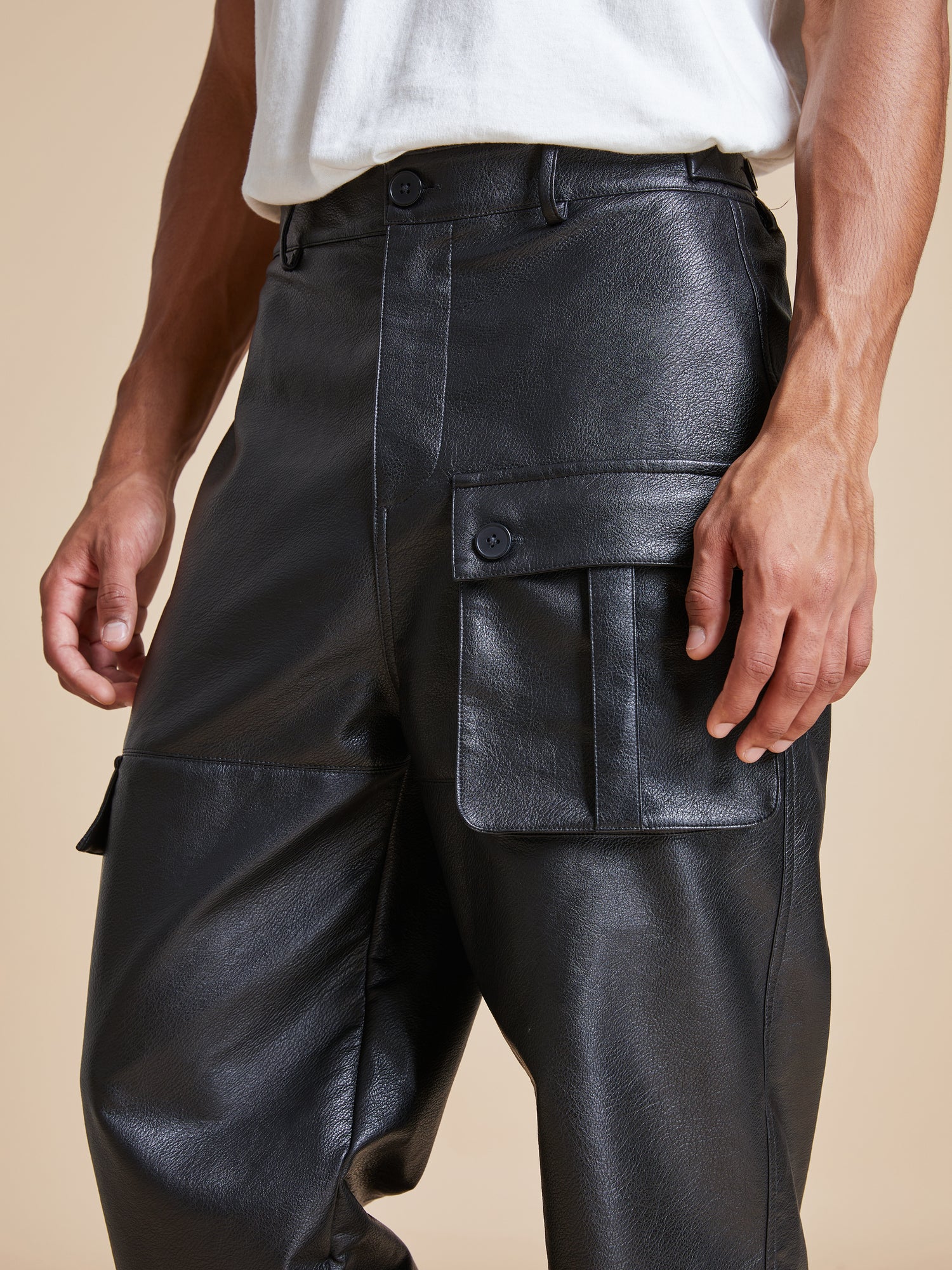 A man wearing Found's faux leather cargo pants.