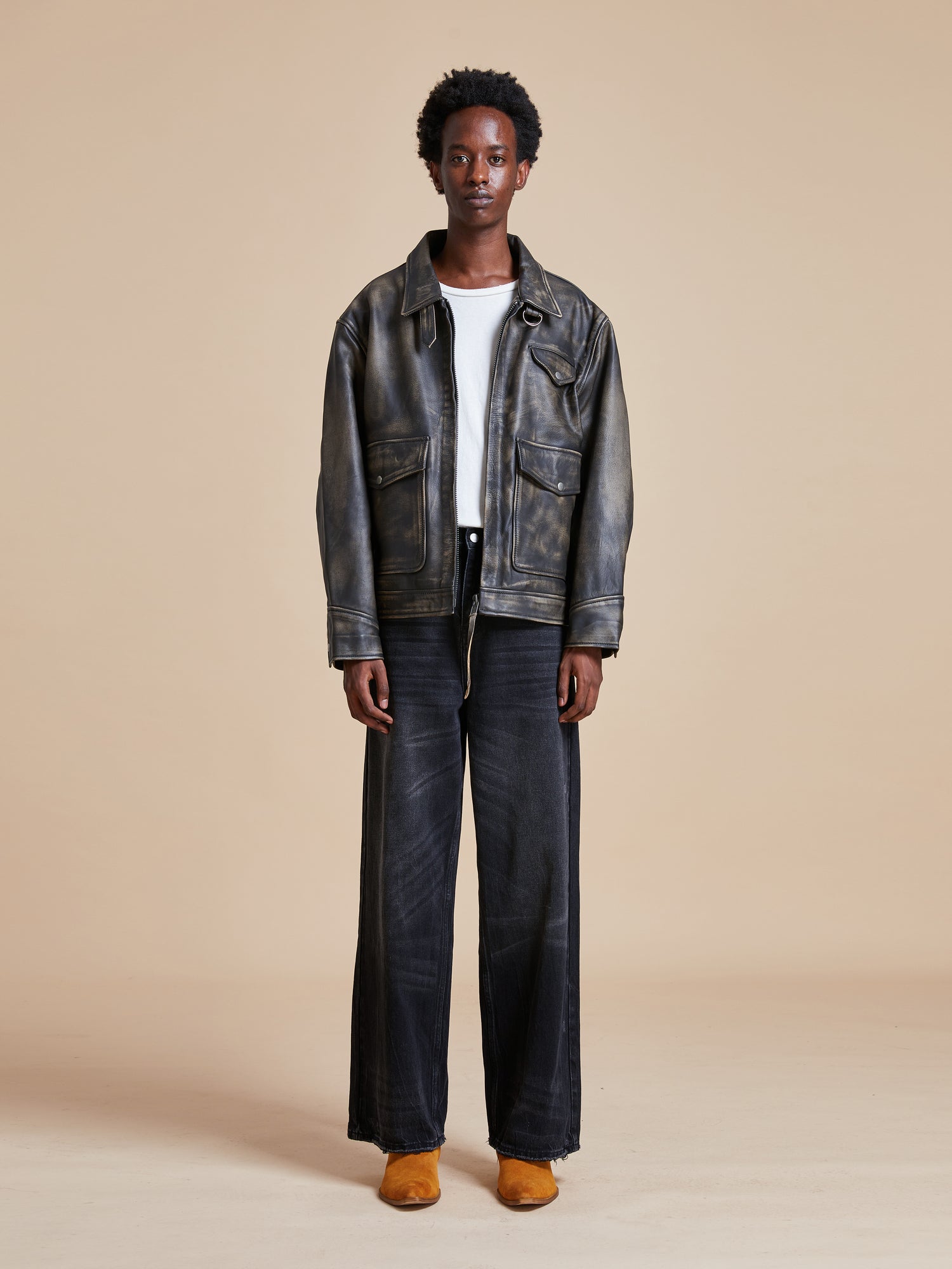 The model is wearing a Found Distressed Leather Pocket Jacket and wide leg pants.