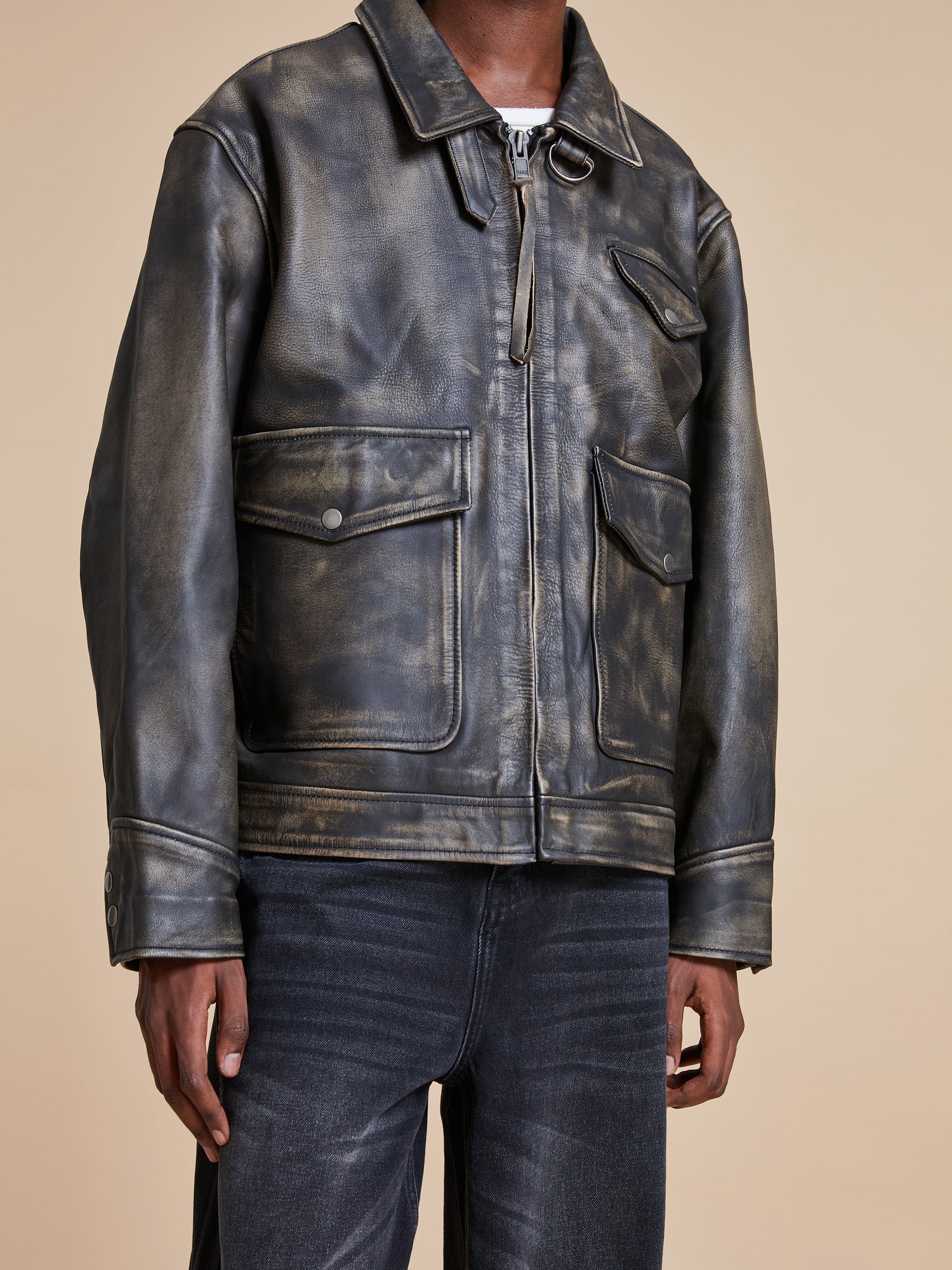 A man wearing a Found Distressed Leather Pocket Jacket and jeans.