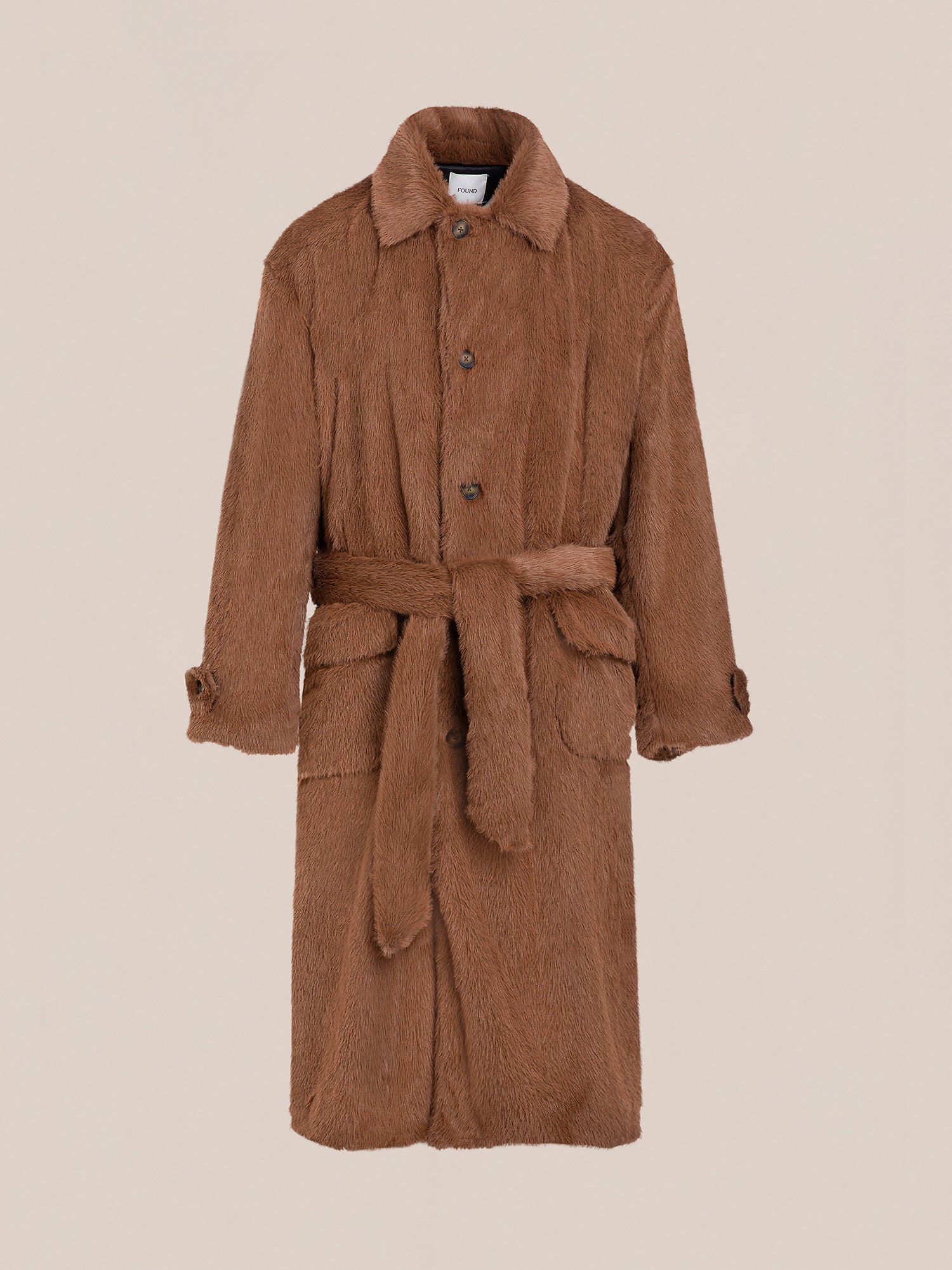 The Long Faux Fur Coat by FOUND showcases a double-breasted design with buttons, a waist tie, long sleeves, and a collar, elegantly presented against a plain backdrop.