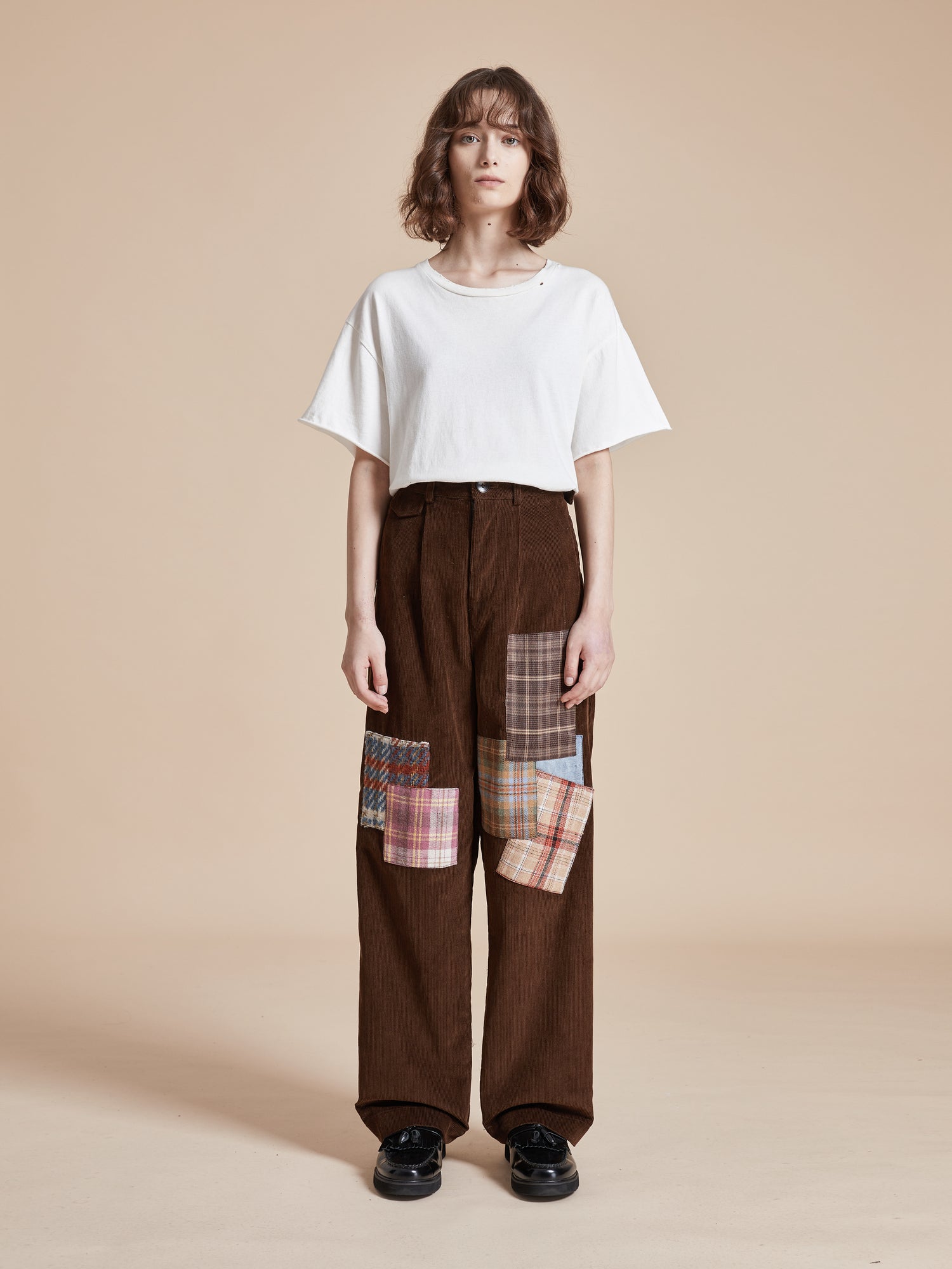 The model is wearing Found Multi-Plaid Patch Corduroy Pants with fabric patches.