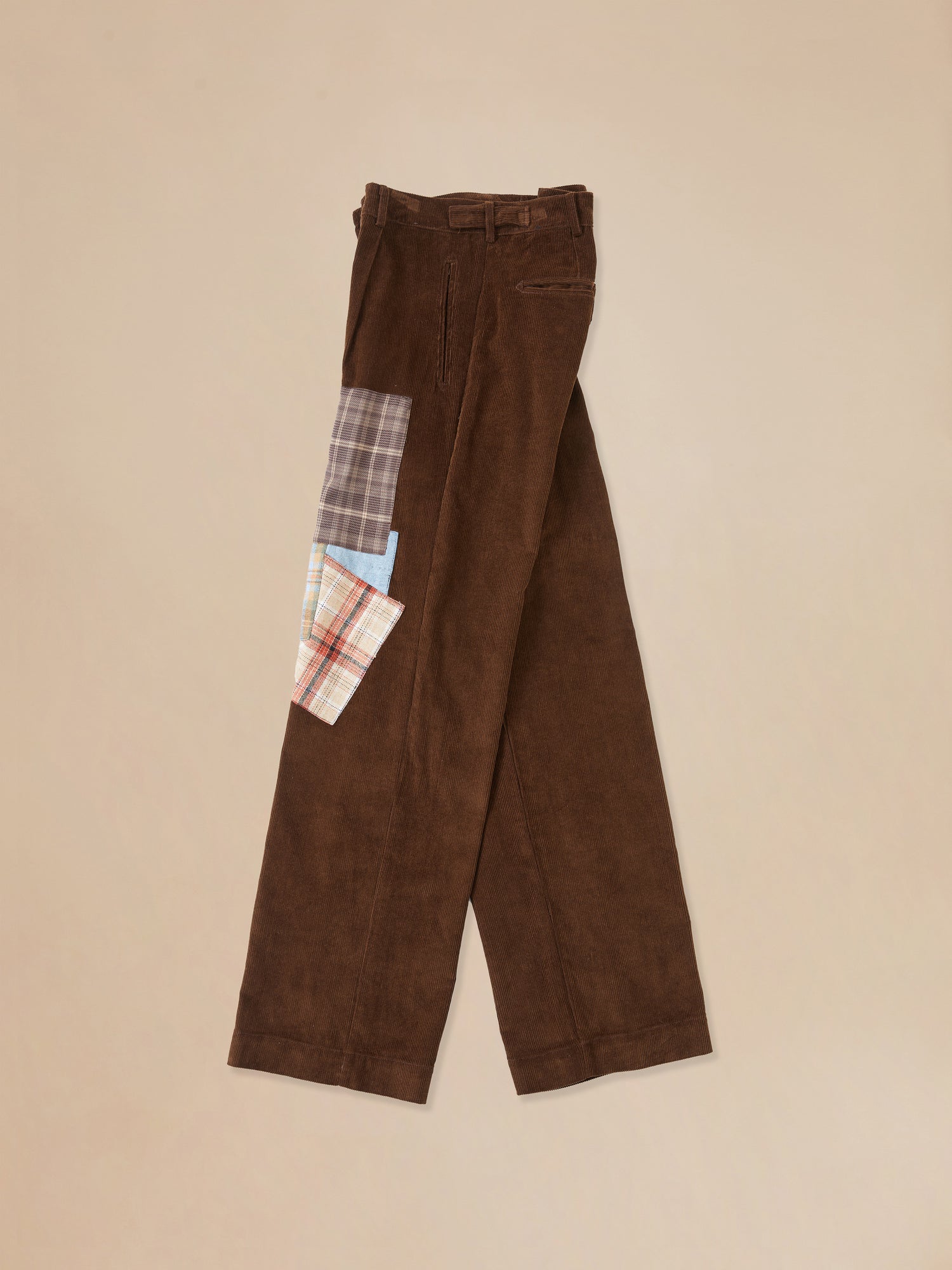 A pair of Multi-Plaid Patch corduroy pants from Found with fabric patches.