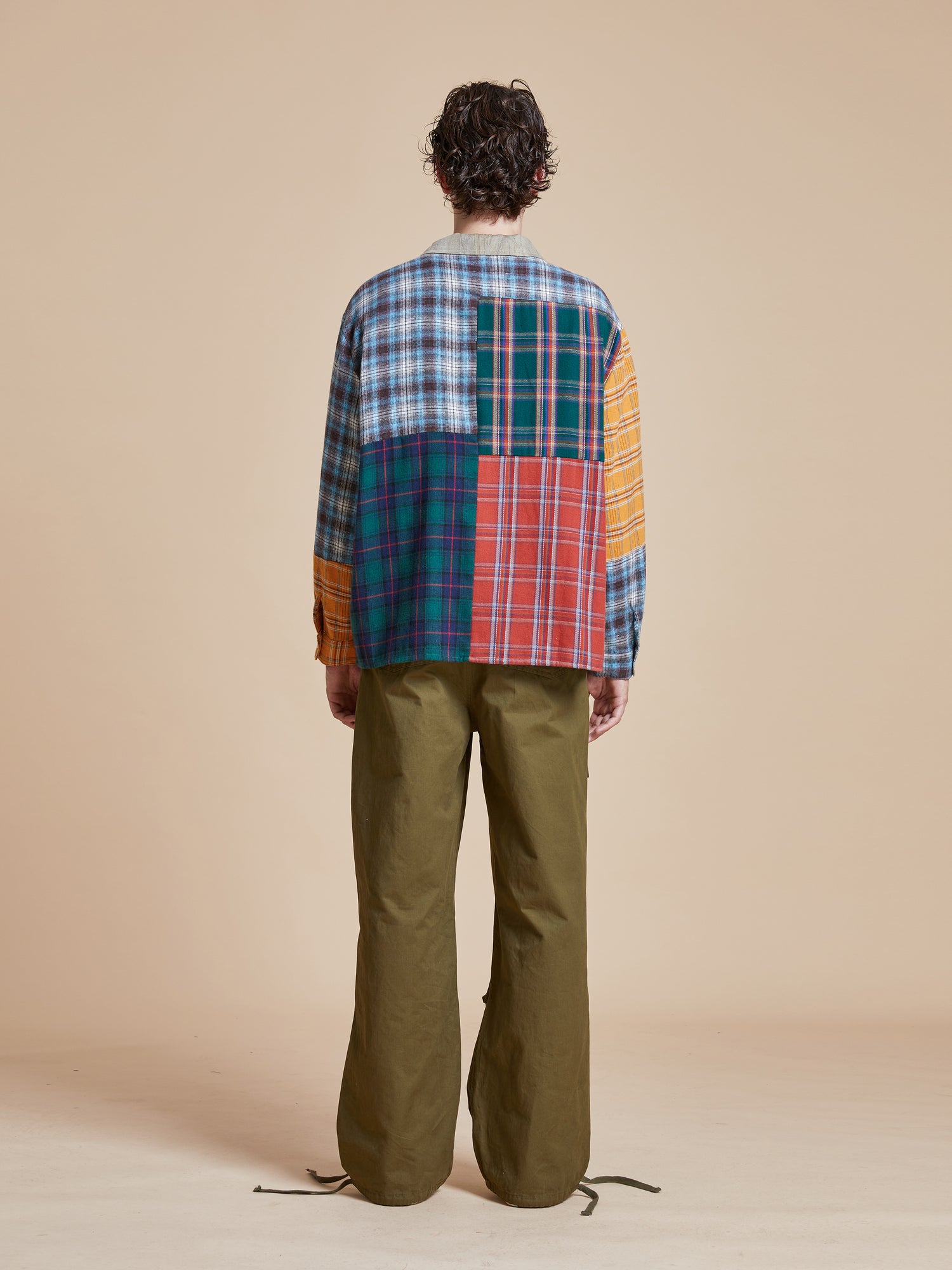 The back view of a man wearing a Found Multi Plaid Tartan Shirt and pants.
