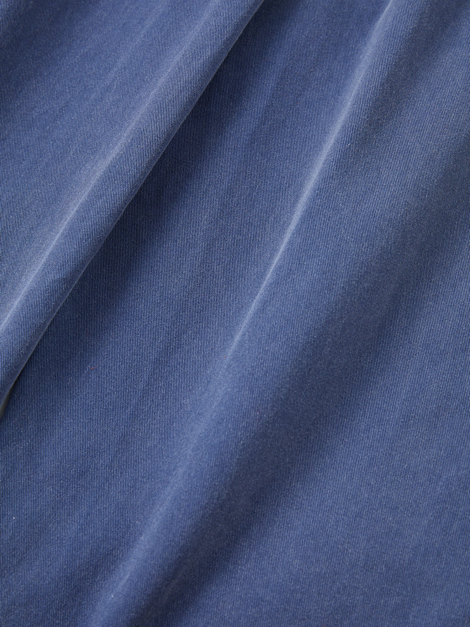 A close up image of Found River Painters Chore Pants in a blue fabric.