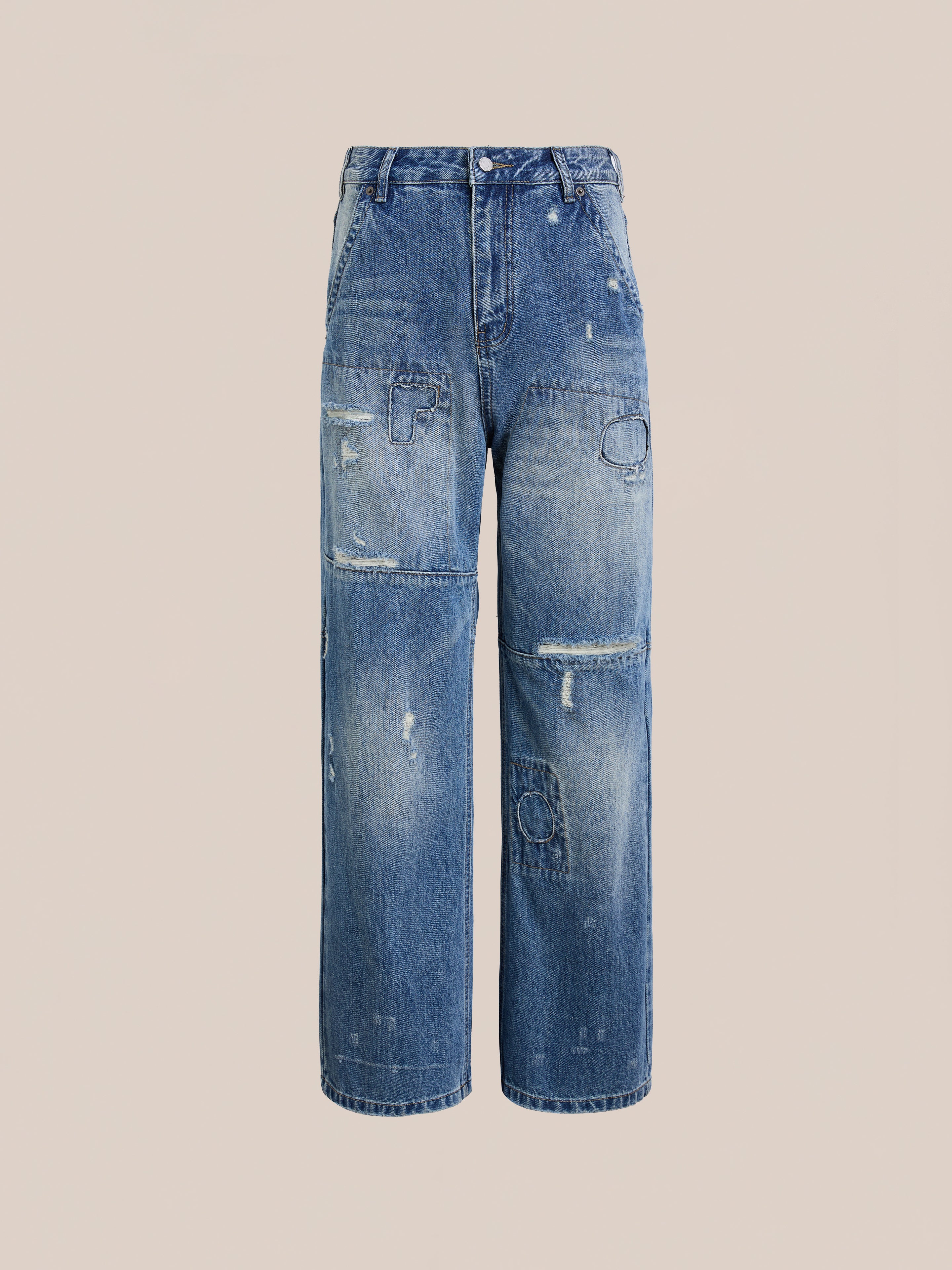 The FOUND Painter Repaired Jeans are high-waisted vintage denim with a straight-leg cut, featuring distressed patches and frayed front details for a classic patchwork look.