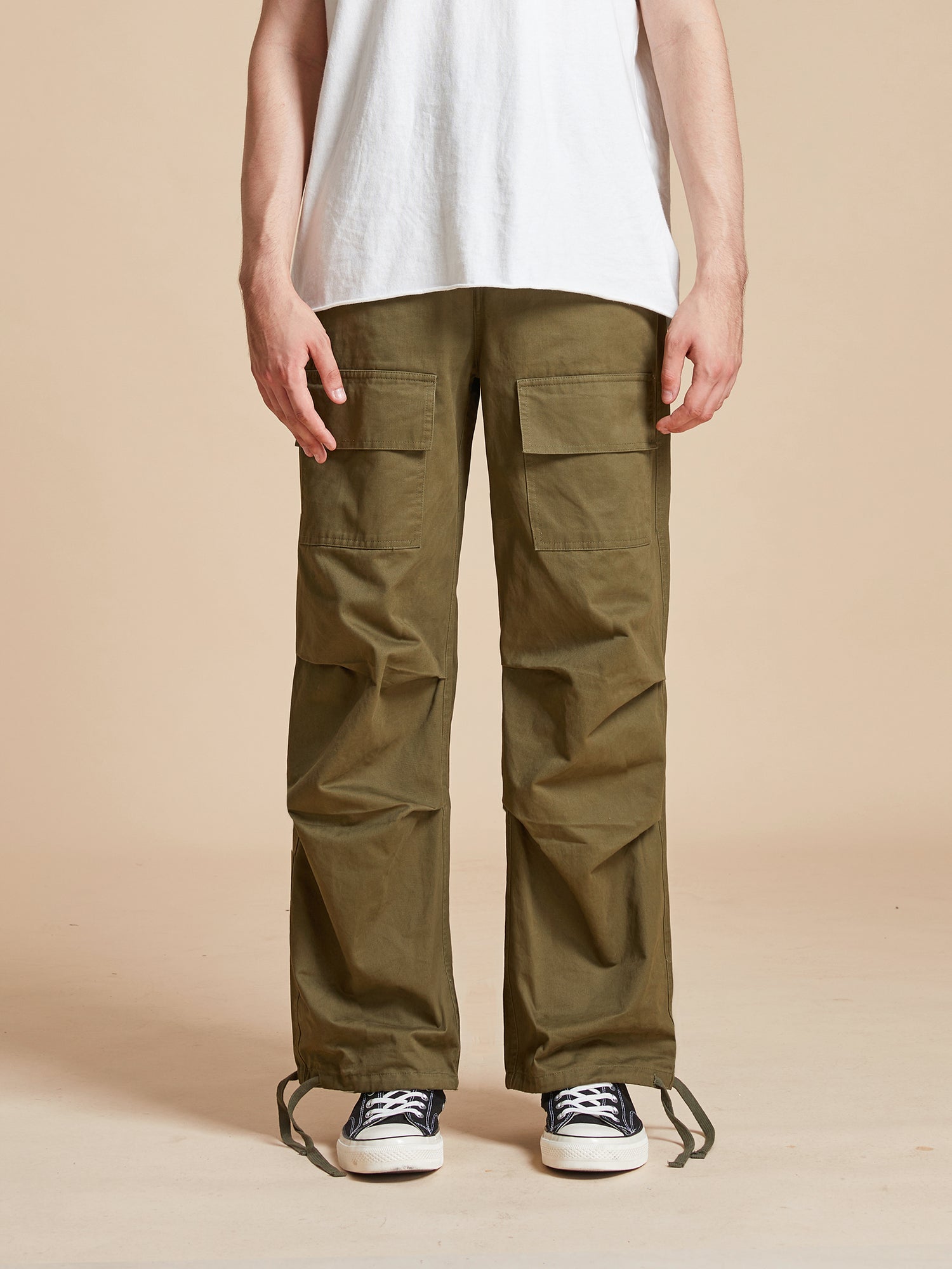 A man wearing Found's Parachute Cargo Twill Pants and a white t-shirt.
