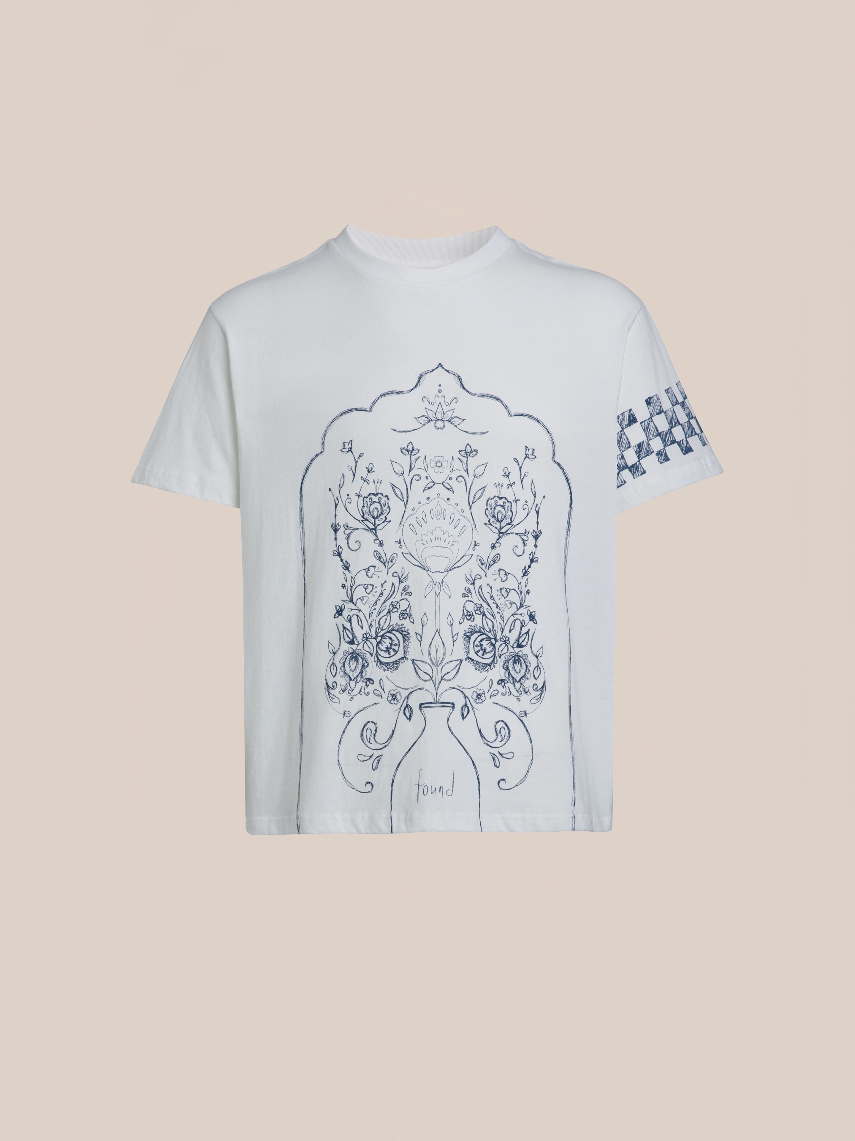 Introducing the Pen Flower Medley White T-shirt by FOUND, showcasing an intricate dark blue floral design on the front and a small checkered pattern on one sleeve against a plain background.