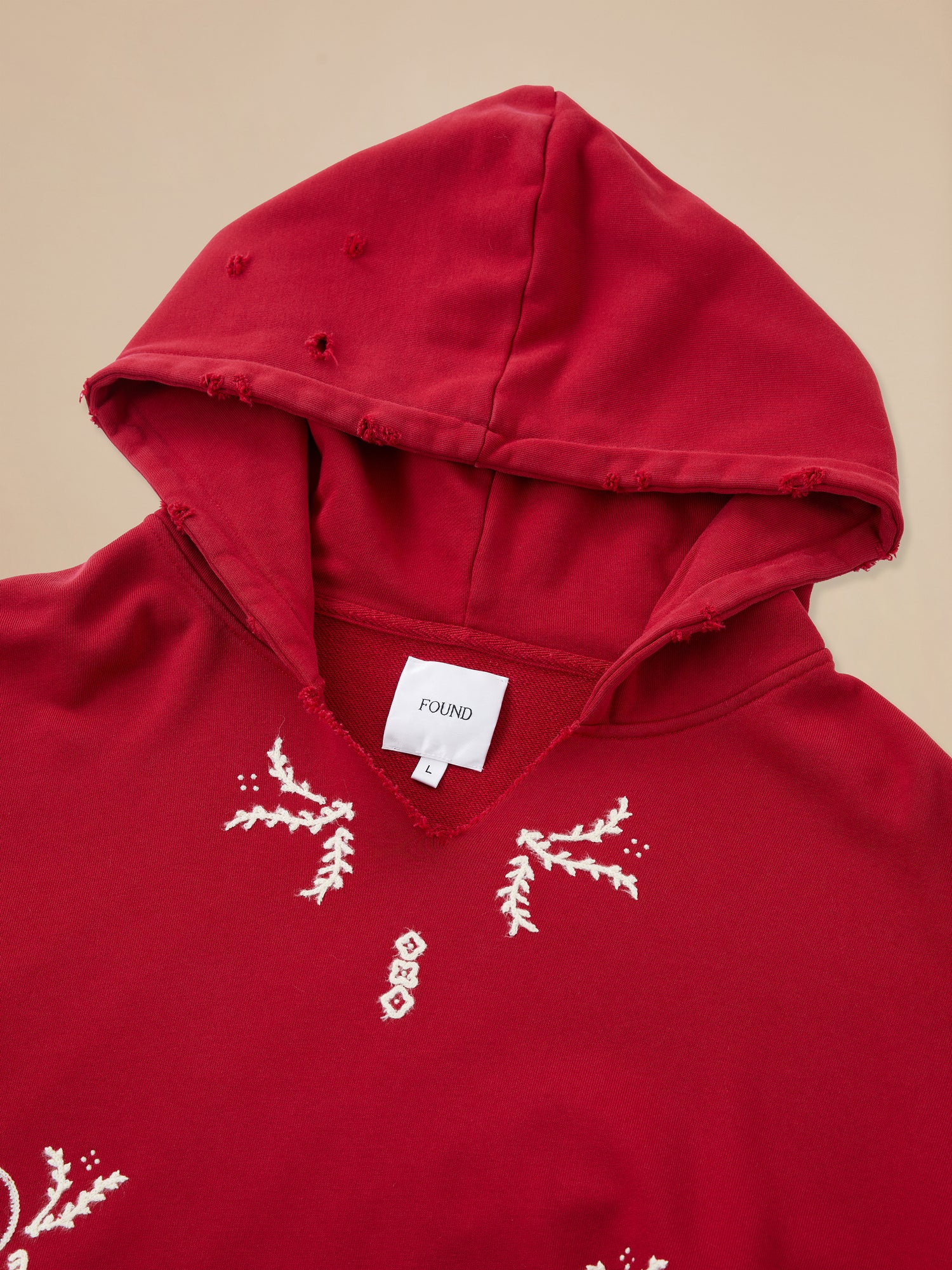 A Phulkari Embroidered Hoodie by Found, with red color and white embroidery on it.