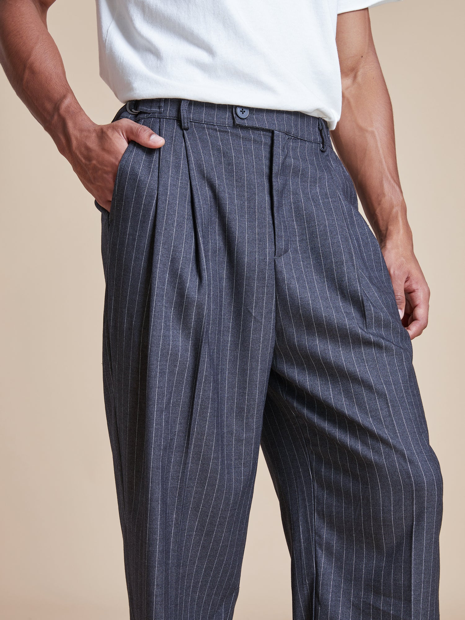 A man wearing Found Pinstripe Pleated Trousers.