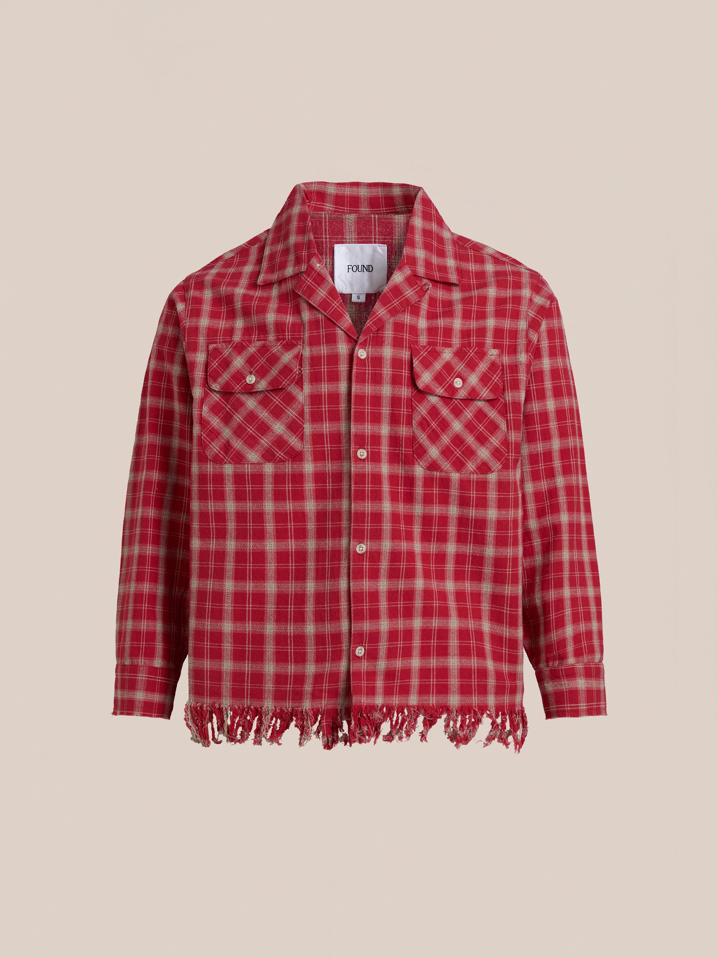 Enjoy cozy comfort in our FOUND Raw Cut Fringe Plaid Camp Shirt, a red plaid button-up made from brushed cotton, featuring long sleeves, fringe hem, and two chest pockets with button flaps.