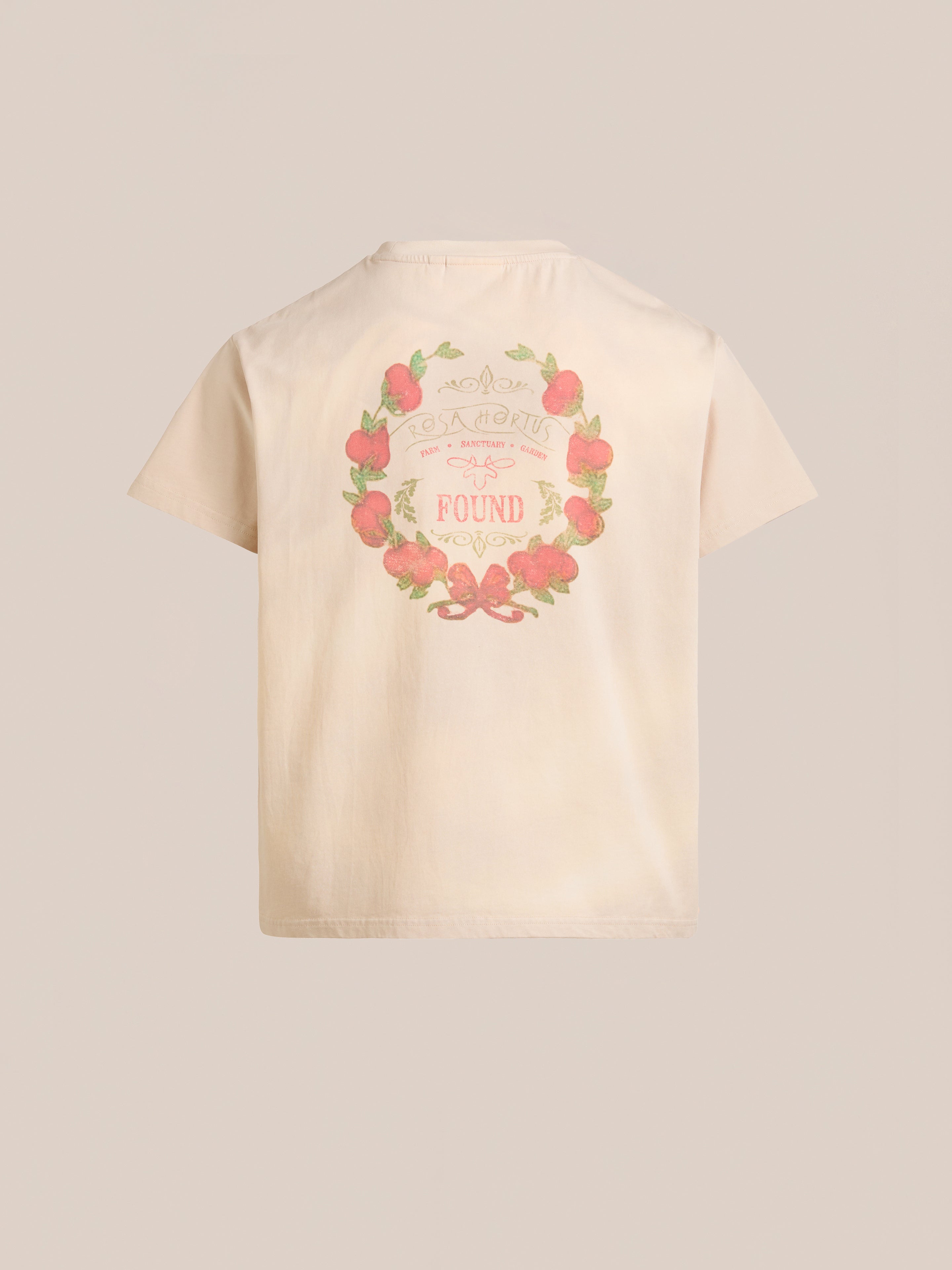 Back view of a beige Rose Garden Tee by FOUND, featuring a vibrant circular design with strawberries, leaves, and the word "FOUNDED" in the center, exuding vintage charm.