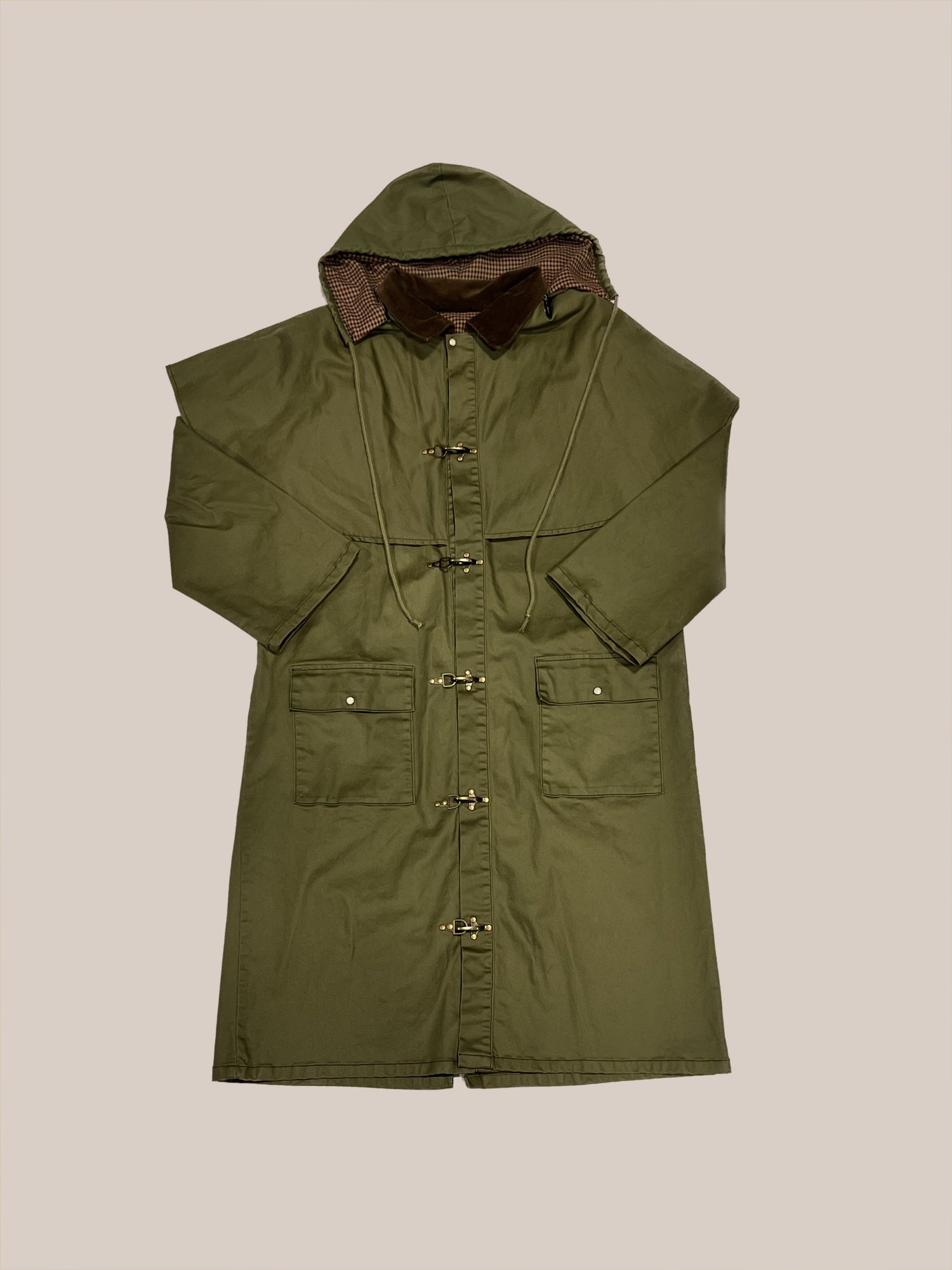 Heavy garment: Olive green, waxed cotton long coat with hood and large pockets displayed on a neutral background by Profound.