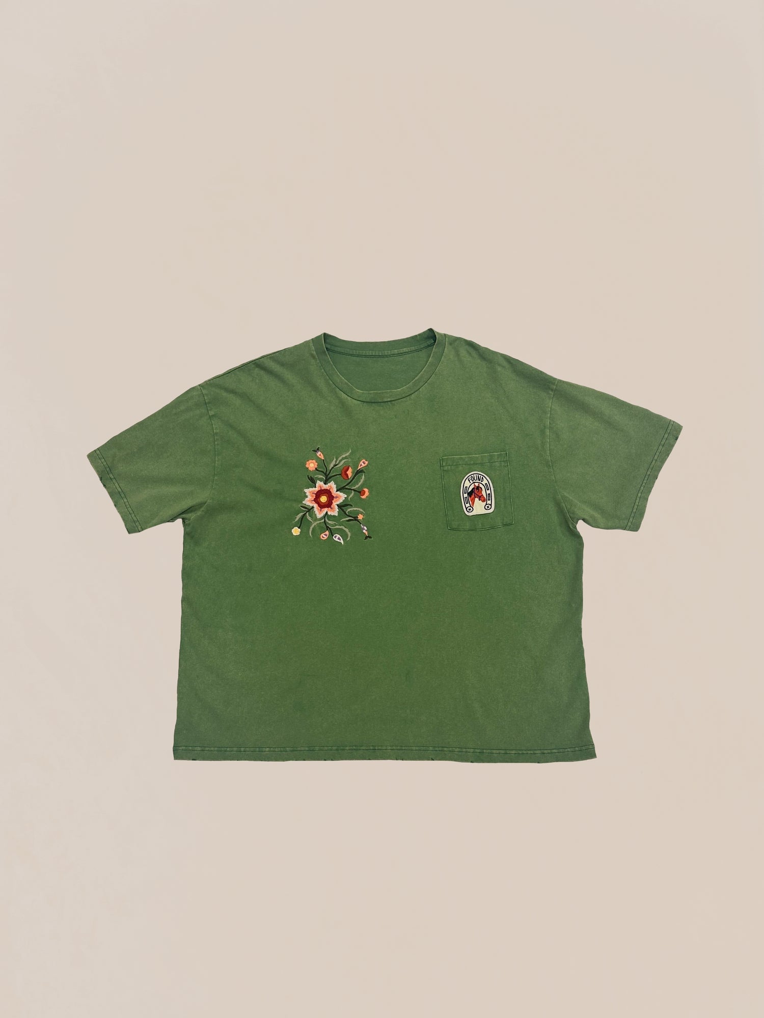 A green Profound 100% Cotton Sample 78 (Pine Needle Farm Tee) with embroidered flower design and a patch on the chest laid flat on a light background.