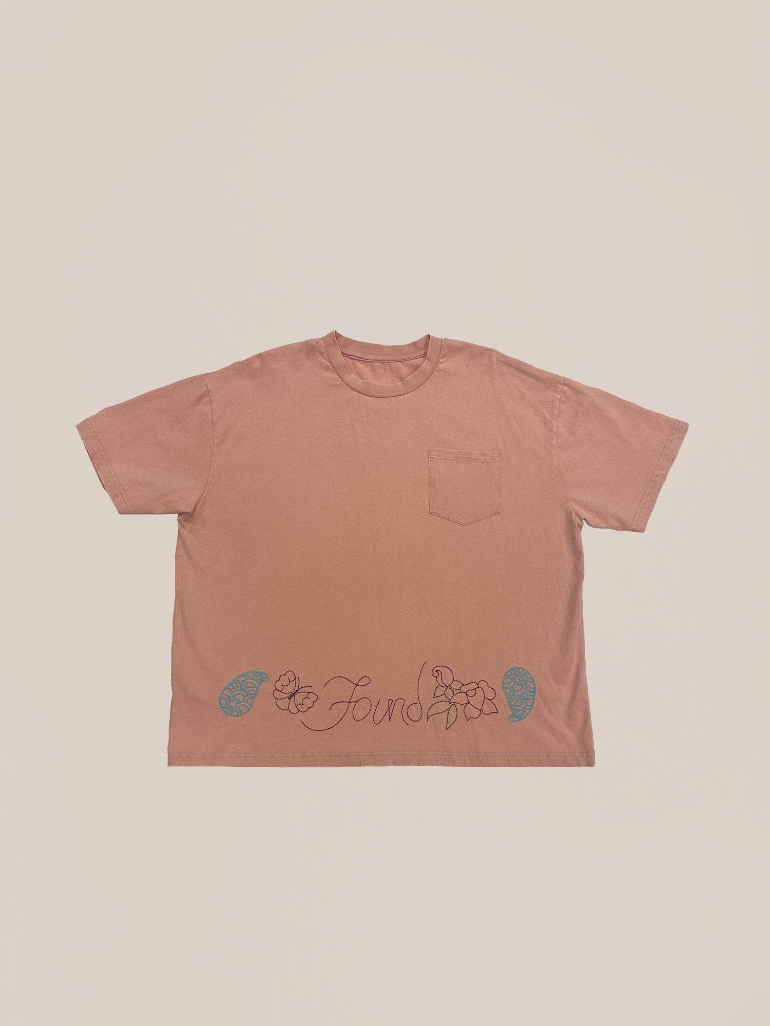 A terracotta-colored, 100% Cotton Sample 80 (Salmon Tee) t-shirt by Profound with decorative graphics and text at the bottom front.