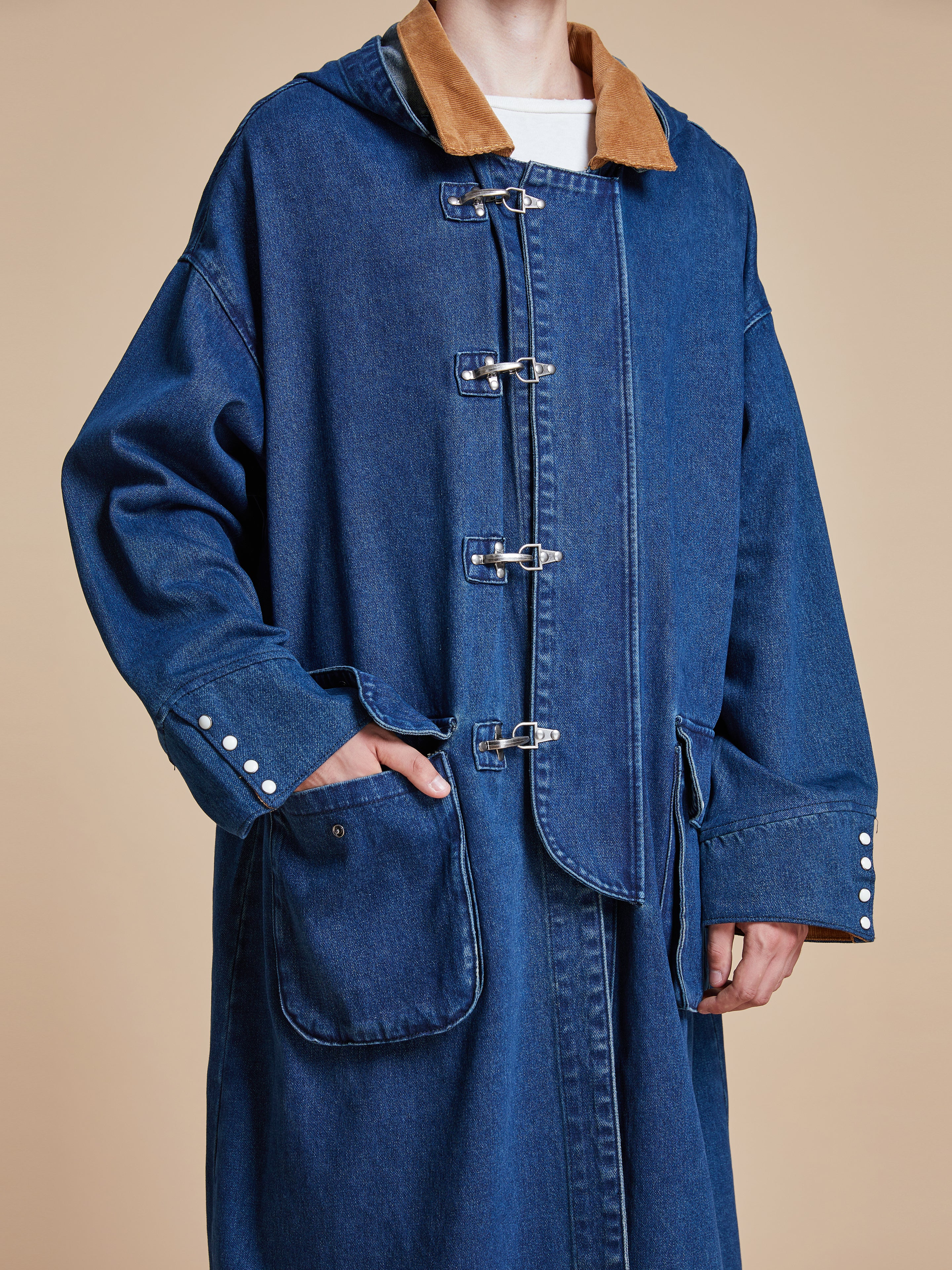 A man wearing a Found Sargasso Denim Buckle Coat.