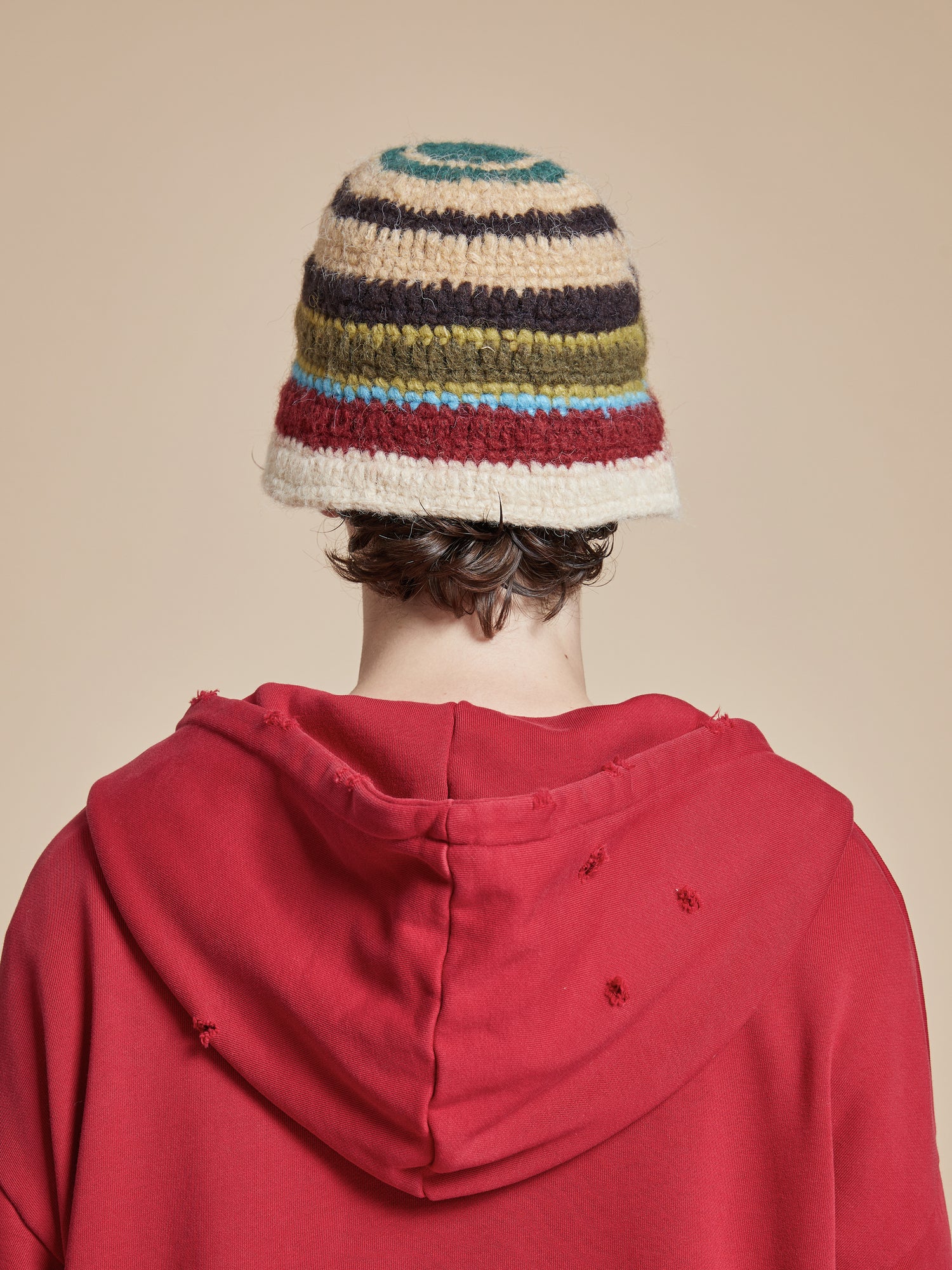 A man wearing a Found Stripe Knit Beanie hat.
