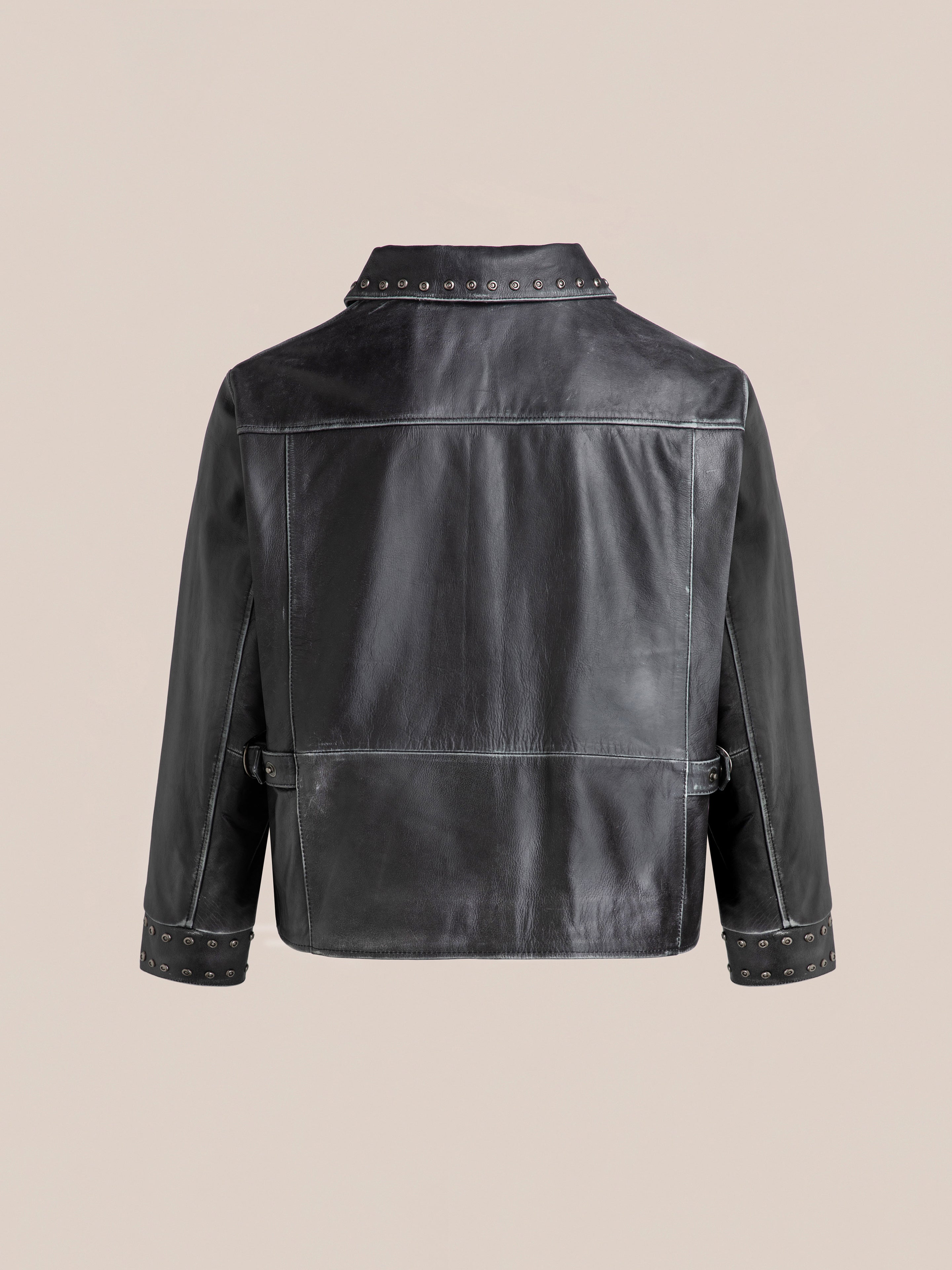 Back view of Found's Studded Leather Pocket Jacket, a vintage black leather design featuring studded collar, cuffs, and waistband, set against a plain beige background.