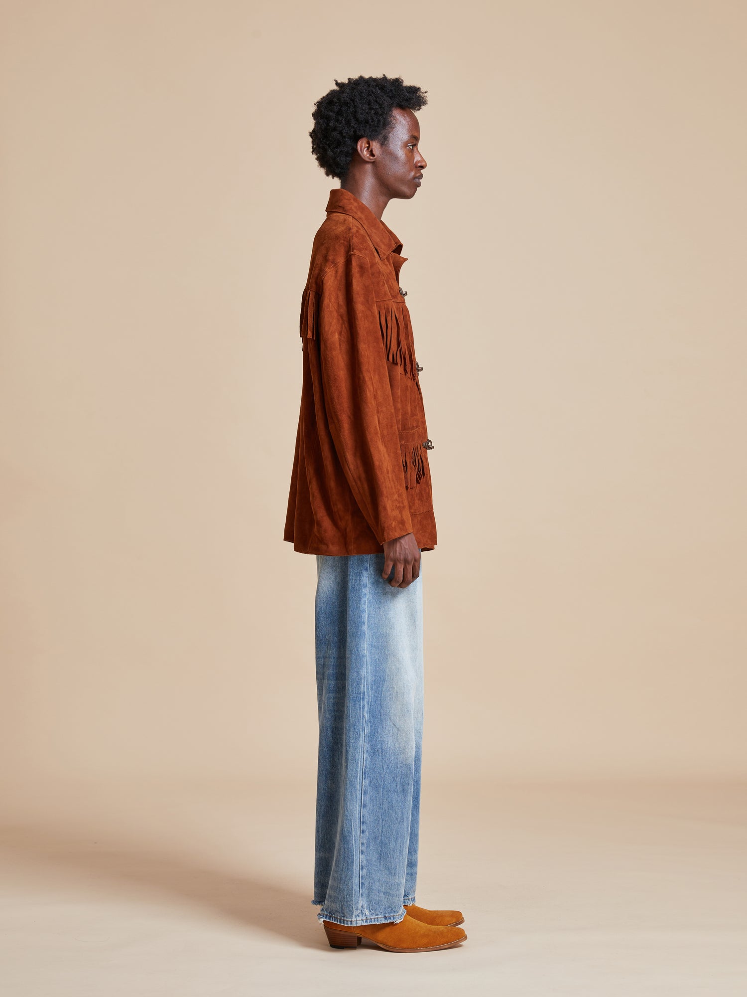 Male model wearing the tobacco fringe suede buckle jacket from Found's Fall 2023 collection