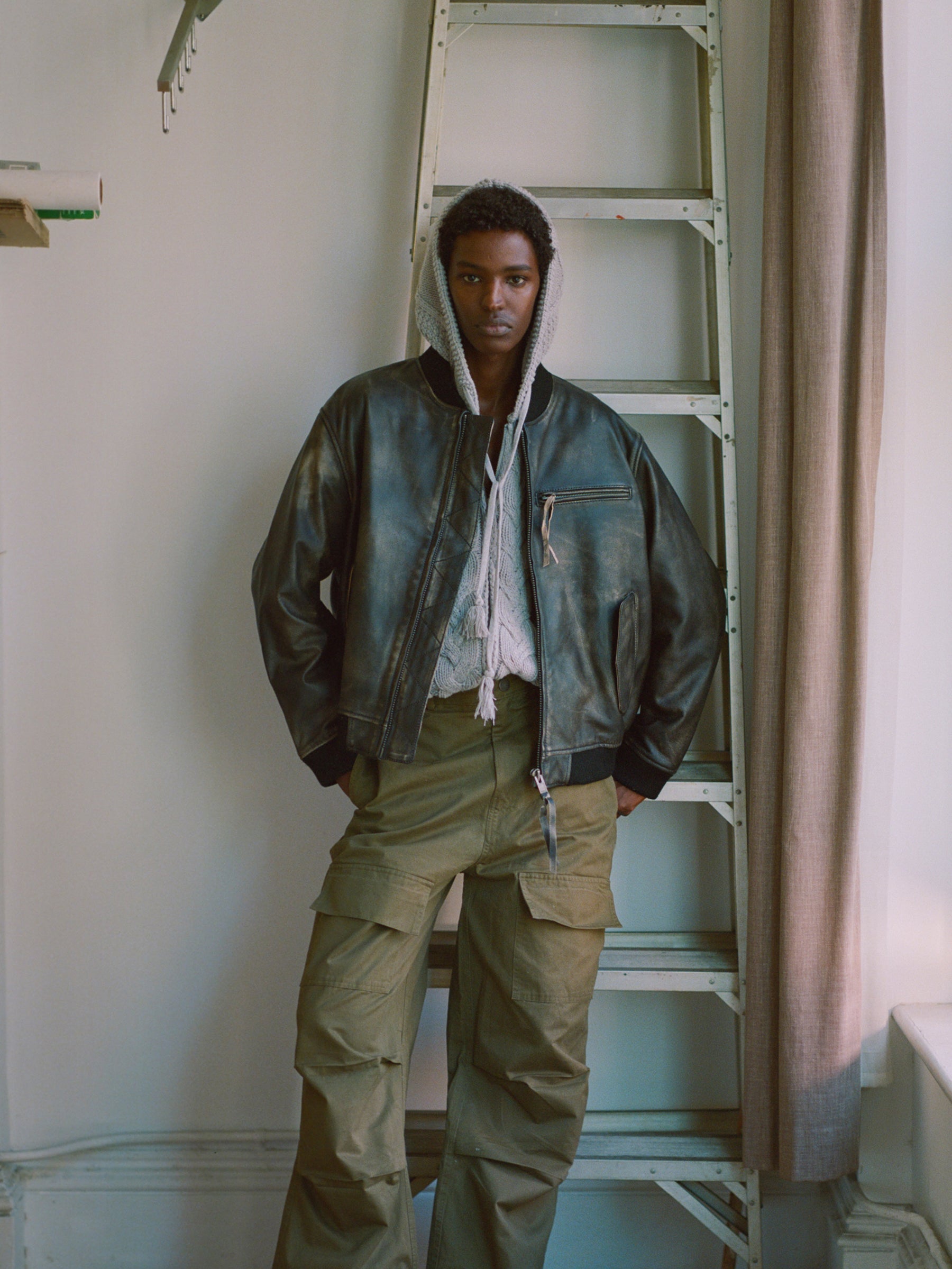 A man standing on a ladder in a Found Distressed Pavement Leather Bomber Jacket.