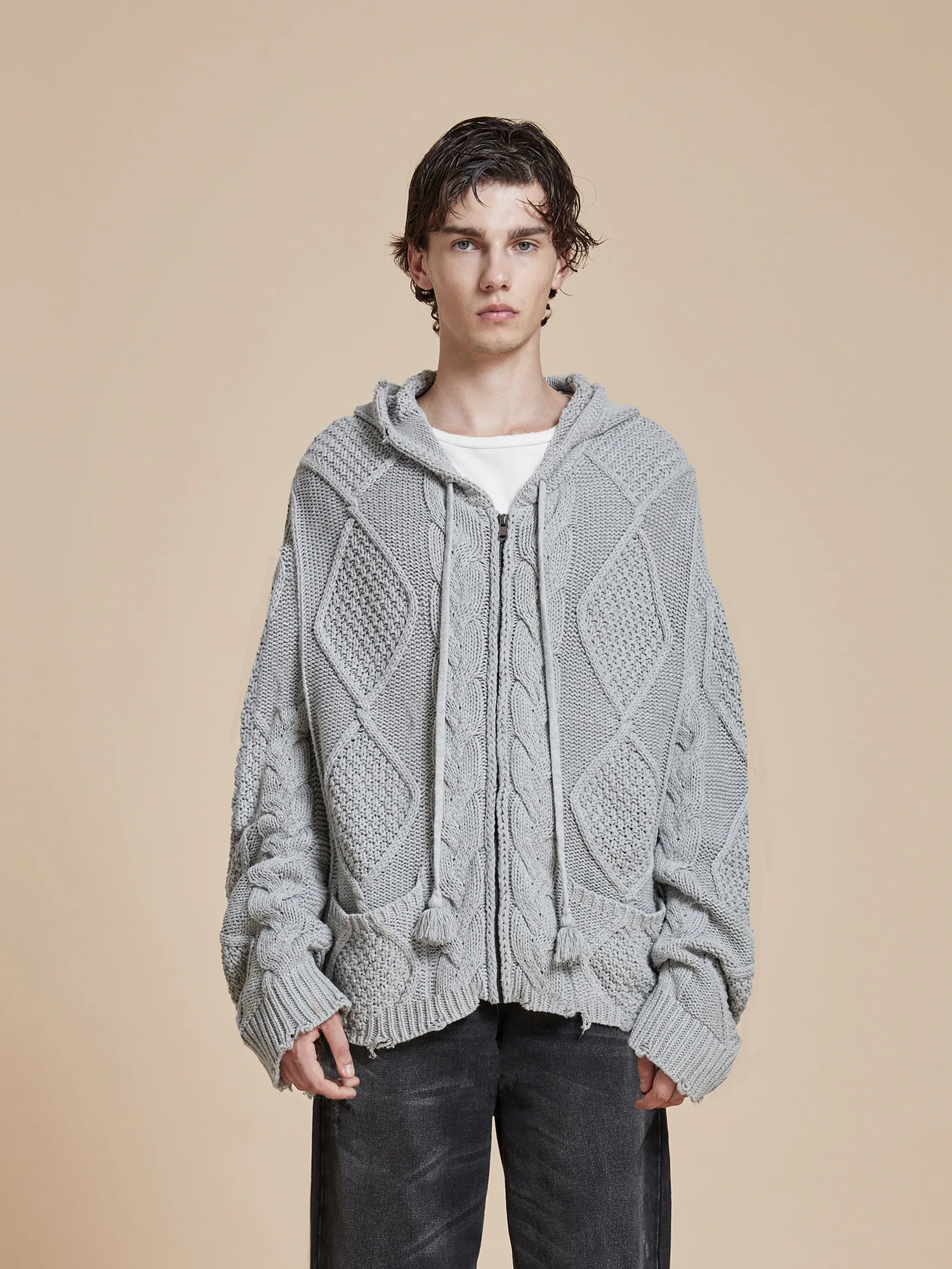 The model is wearing a warm grey Zip Up Distressed Cable Knit Hoodie from Found for comfort.