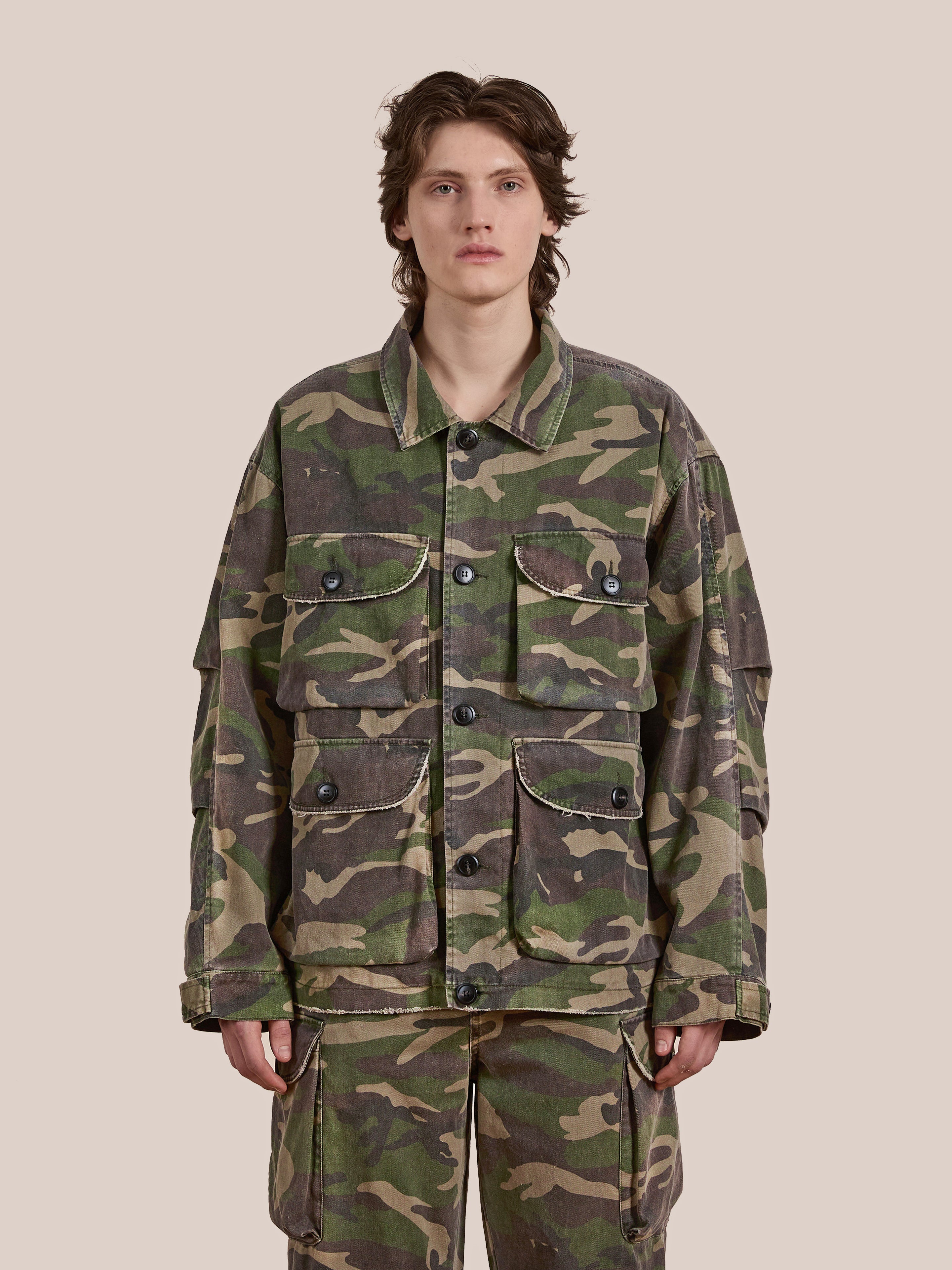 A person is wearing the FOUND Camouflage Twill Utility Cargo Jacket and matching pants, standing against a plain background.