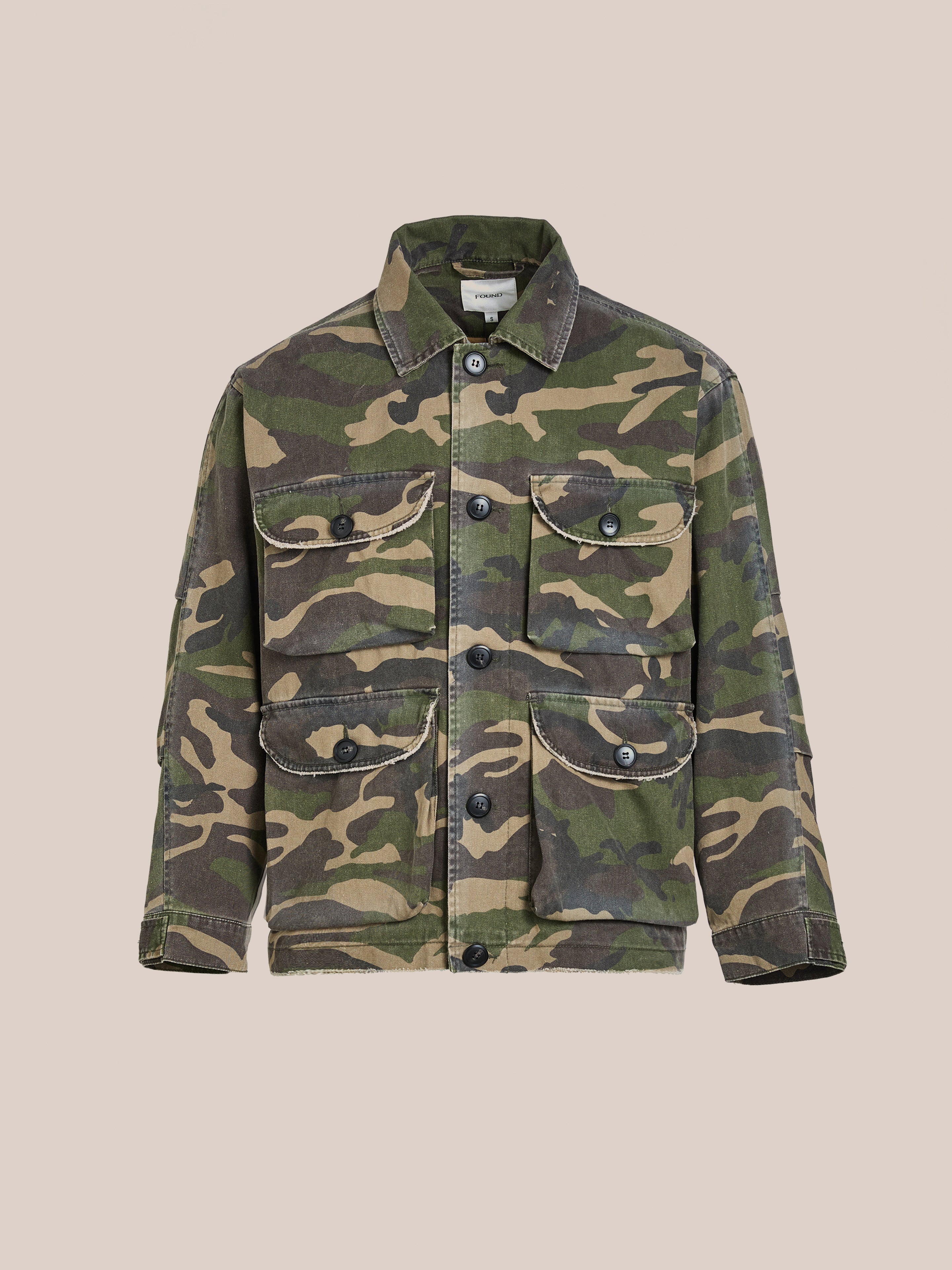 The FOUND Camouflage Twill Utility Cargo Jacket boasts a vintage look with its camouflage pattern, front buttons, and multiple pockets.