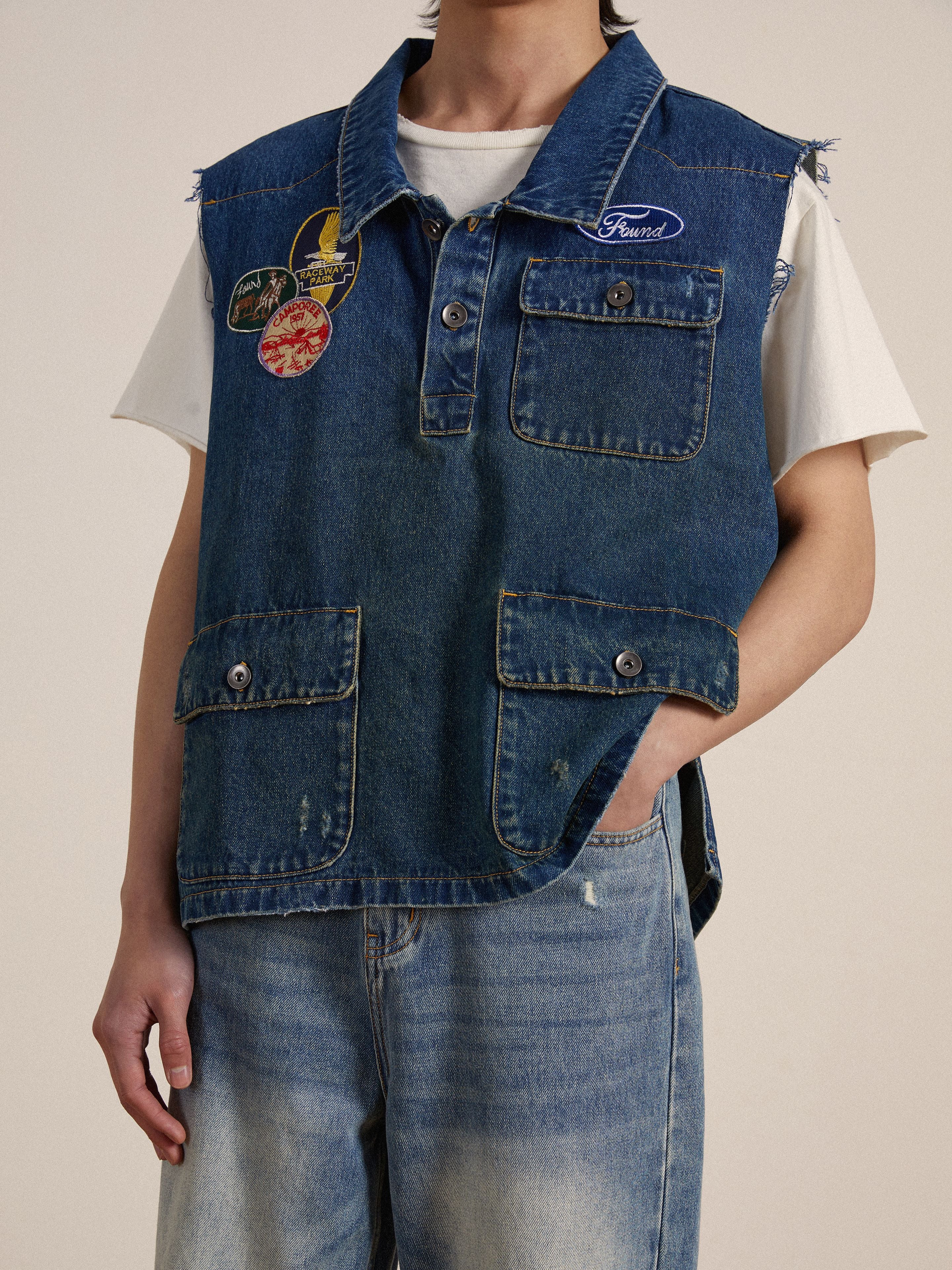 A person wearing a Found Raw Cut Patch Mechanic Denim Vest.