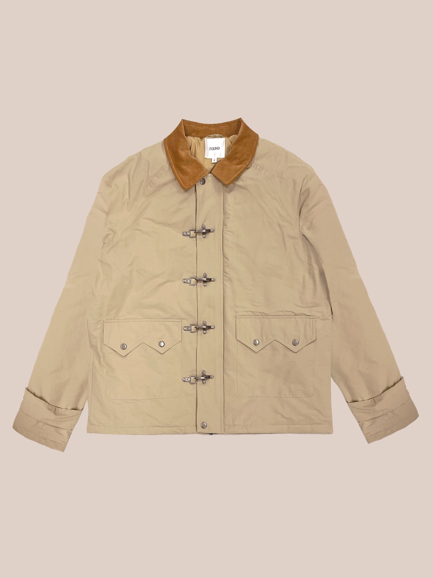 The Fisherman Jacket by FOUND in beige showcases a corduroy collar, antique silver clasps, buttoned closures, and two front pockets set against a plain background.