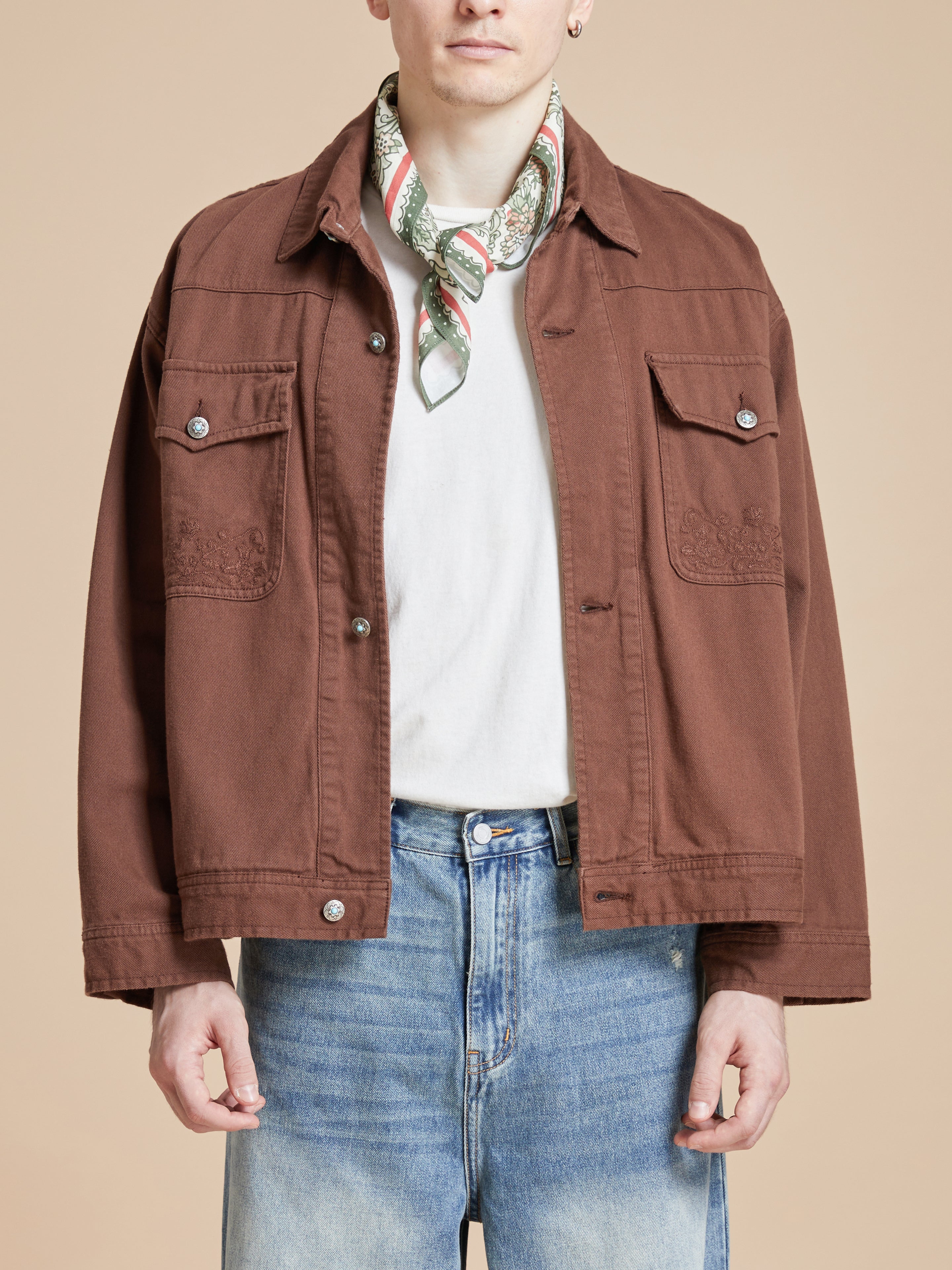 A man wearing the Found Floral Garden Bandana artwork on a brown jacket.