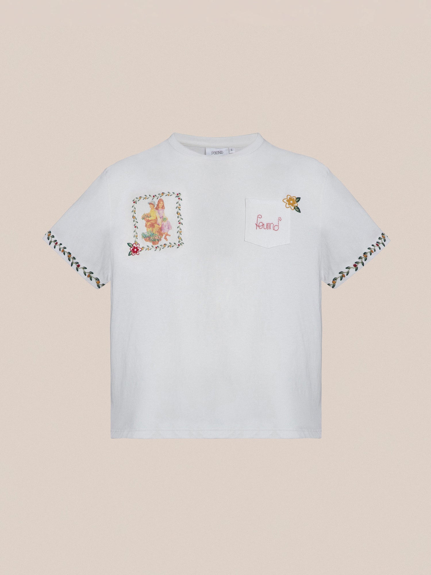 The Flower Children Tee by Found is a white short-sleeve t-shirt featuring vibrant Phulkari style embroideries on the chest, front pocket, and sleeves.