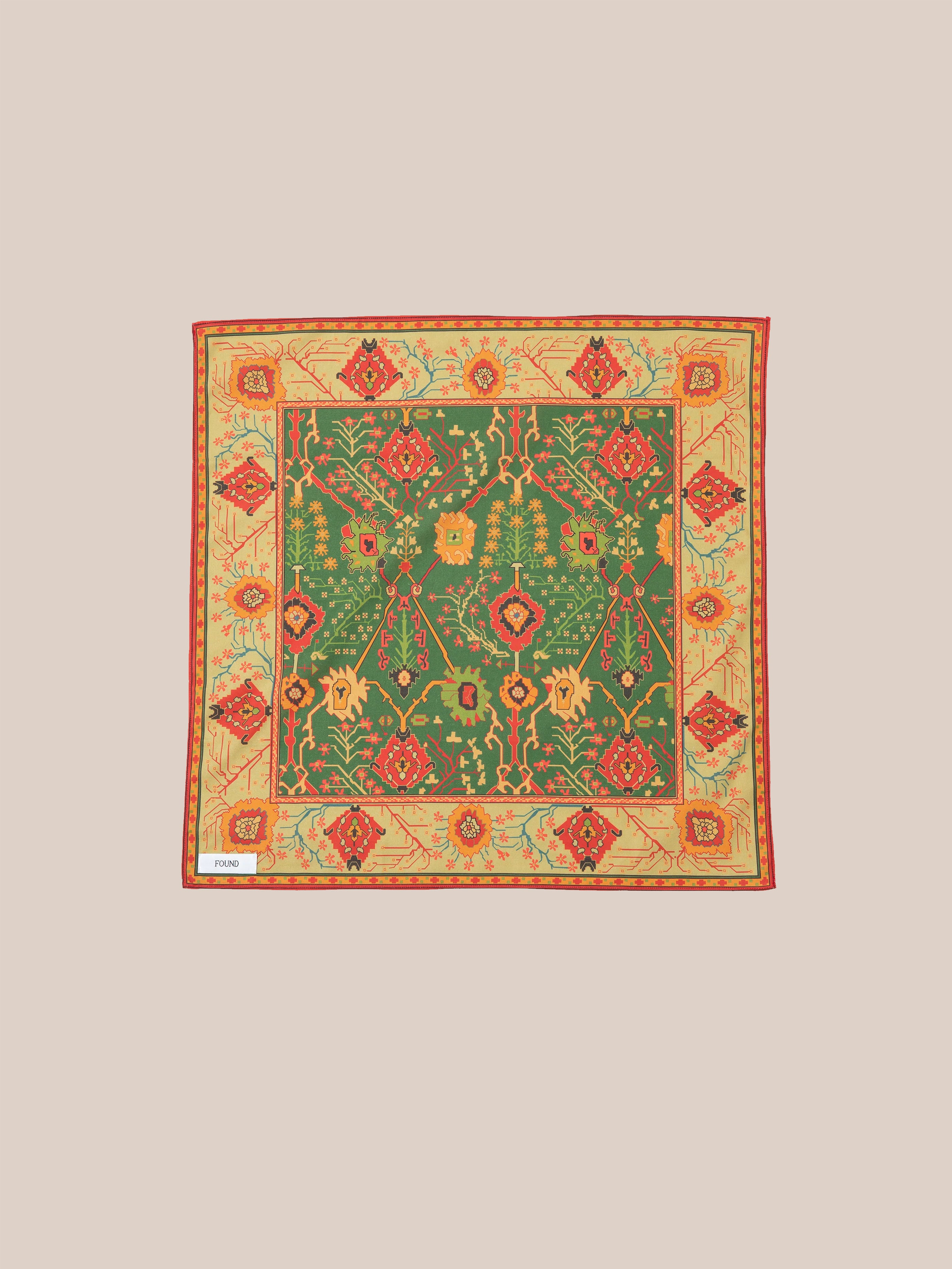 Discover the Botanical Mosaic Bandana by Found, a square scarf made from a soft cotton blend. It features an elaborate floral and geometric design in lively green, red, and yellow hues, inspired by intricate Indo-Aryan prints.