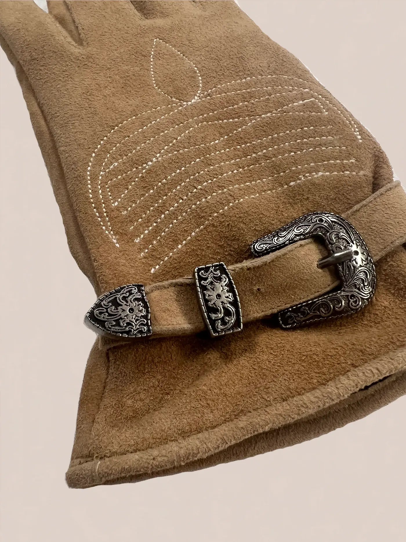 The FOUND Suede Western Gloves are crafted from genuine brown suede and feature stitched detailing and a decorative silver buckle for a timeless Western style.