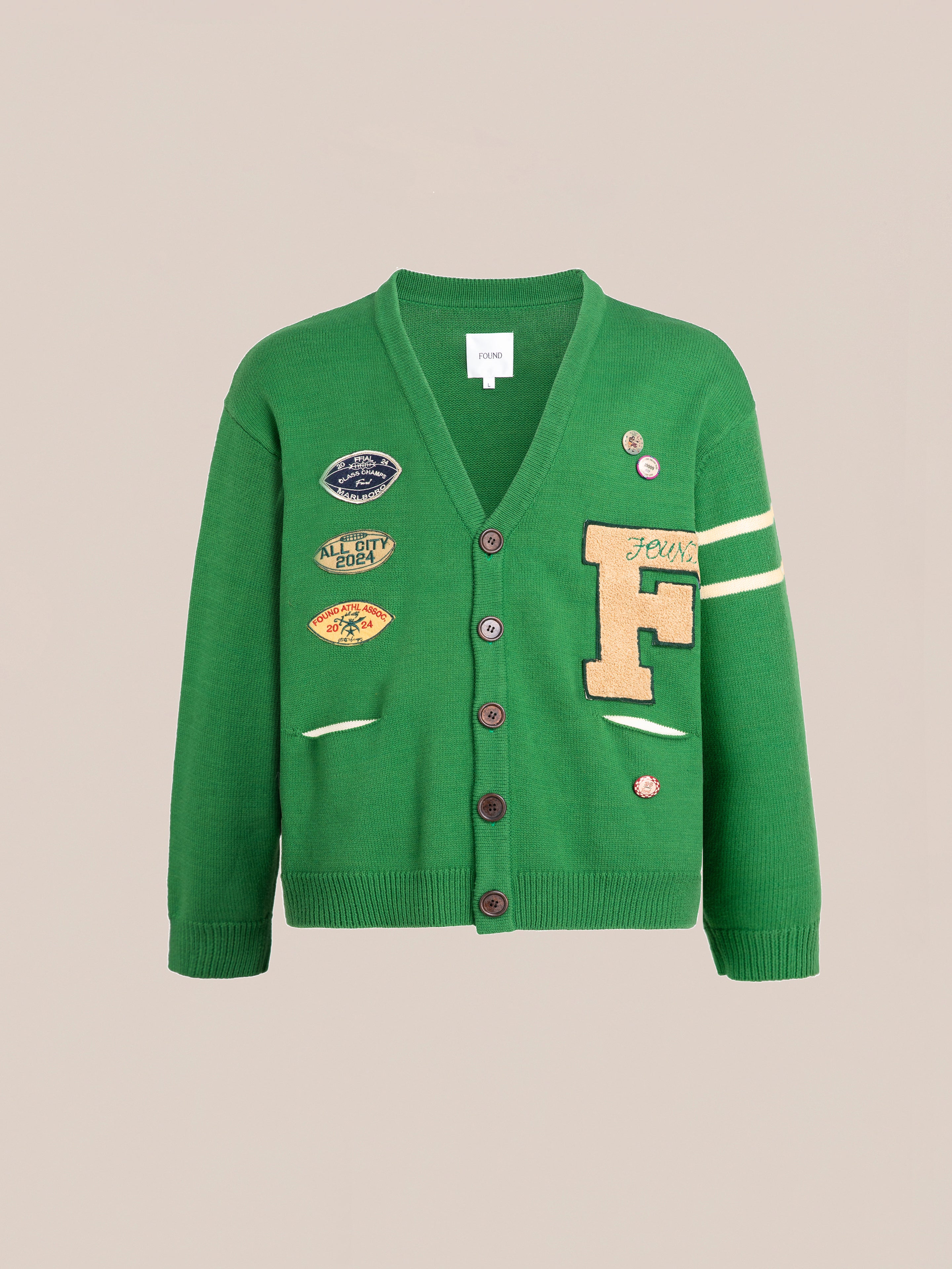 The Pineneedle Varsity Knit Cardigan from FOUND is a green cardigan crafted from 100% cotton knit. It features front buttons, multiple patches including a vintage-style large "F" on the right side, and an arm stripe on the left sleeve.