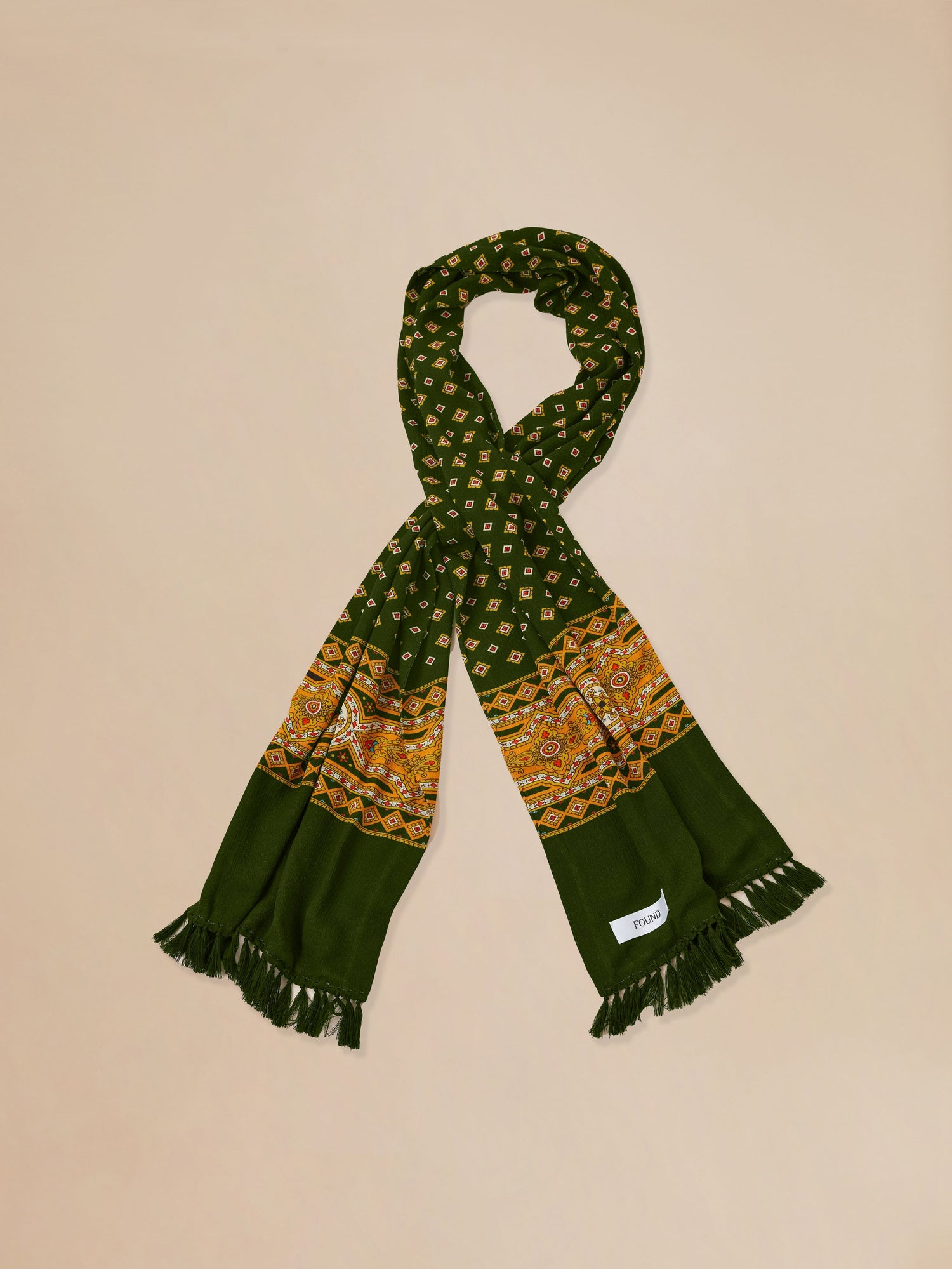An Indo-Aryan Greener Pastures Scarf with tassels on a beige background by Found.