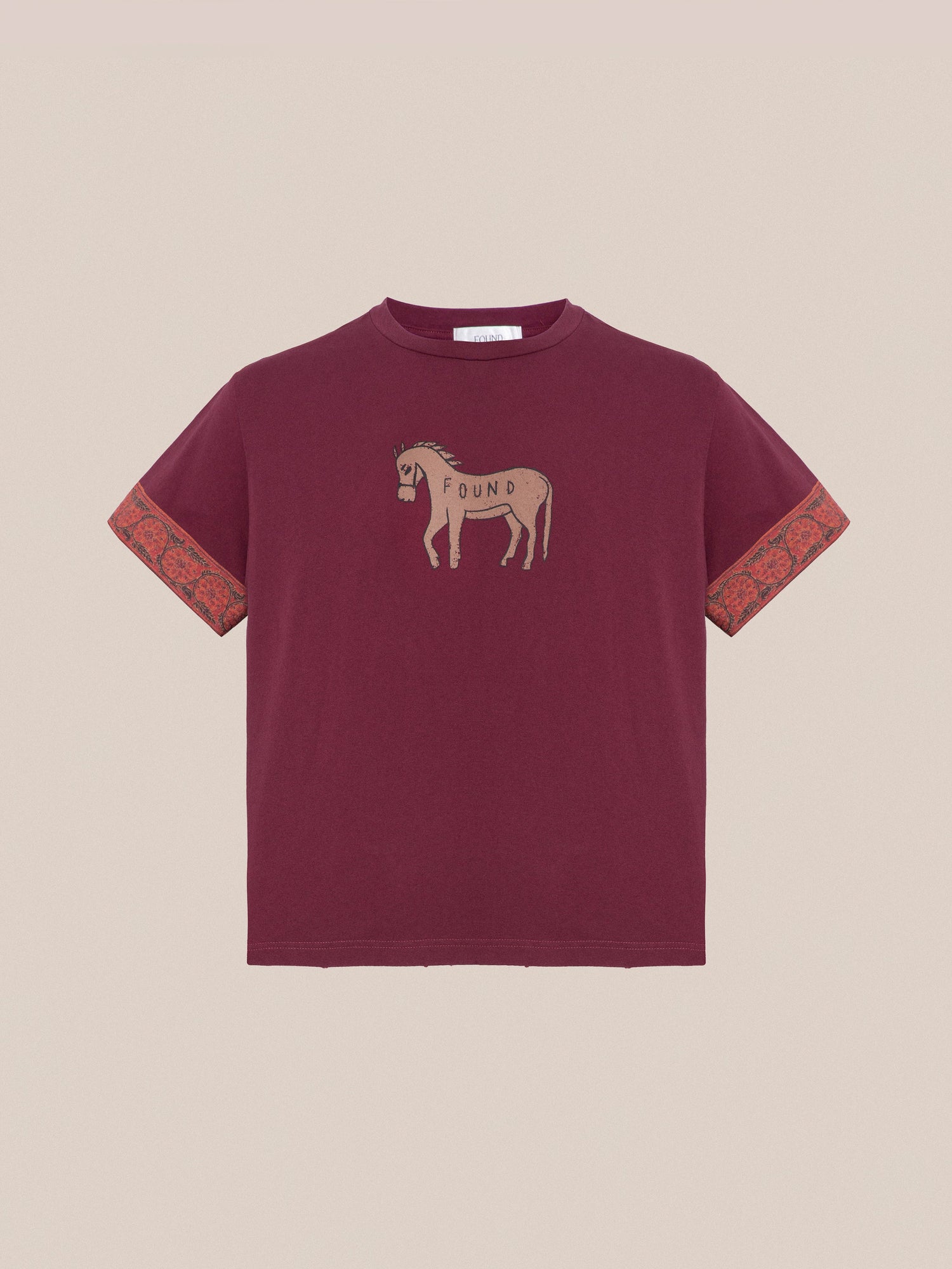 The Horse Embellishment Tee by Found is a maroon T-shirt with a faded purple wash, featuring a donkey graphic and the word 