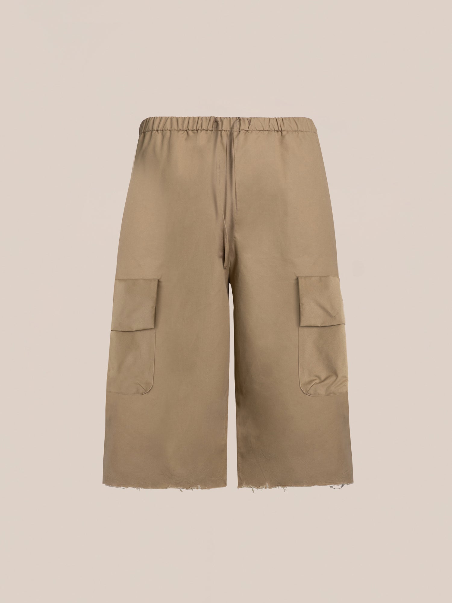 A pair of beige knee-length Long Twill Cargo Shorts by FOUND, featuring an elastic waistband and dual cargo pockets, crafted from lightweight cotton fabric against a plain background.