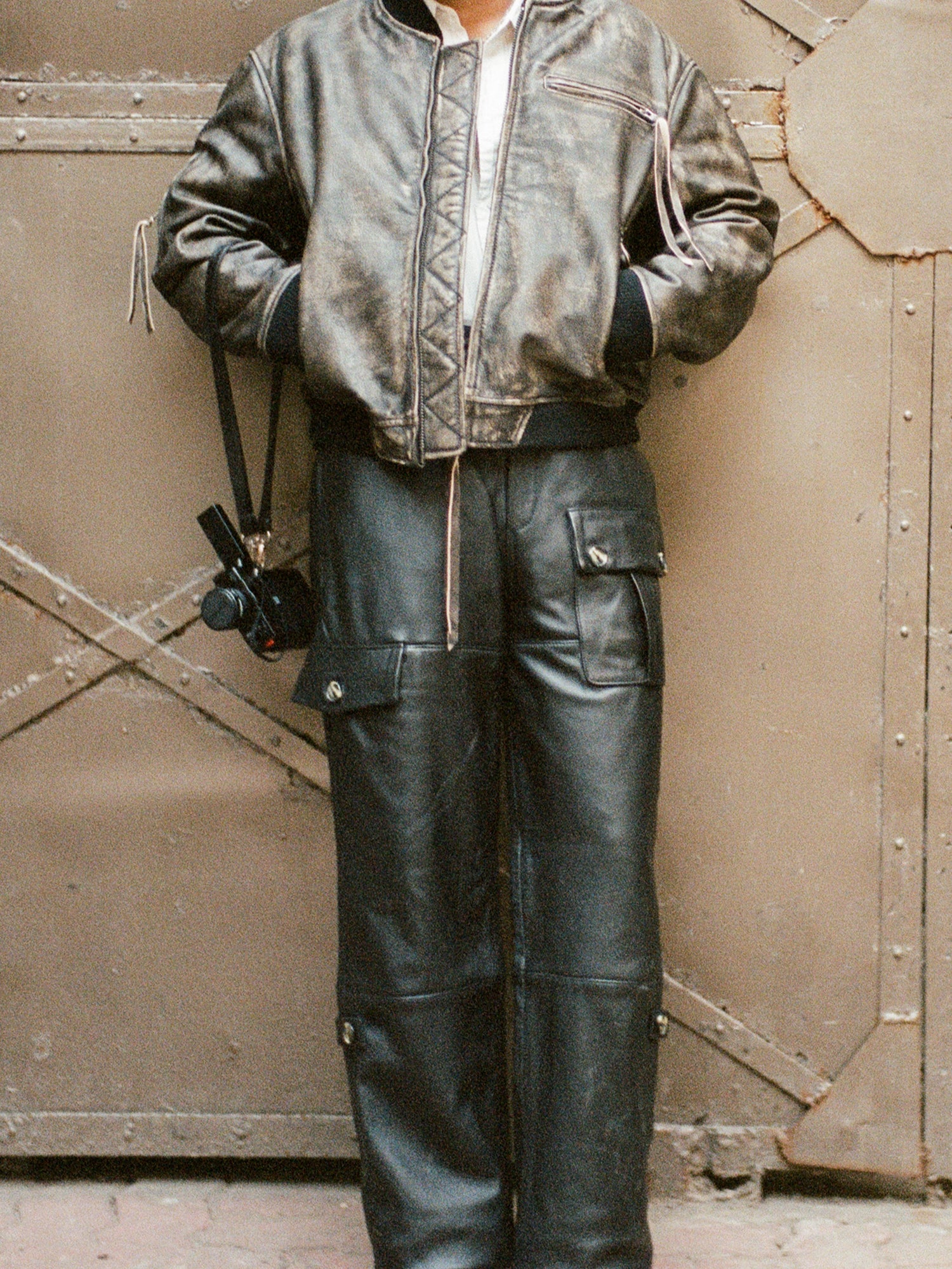 A man donning a leather jacket and Found faux leather cargo pants.