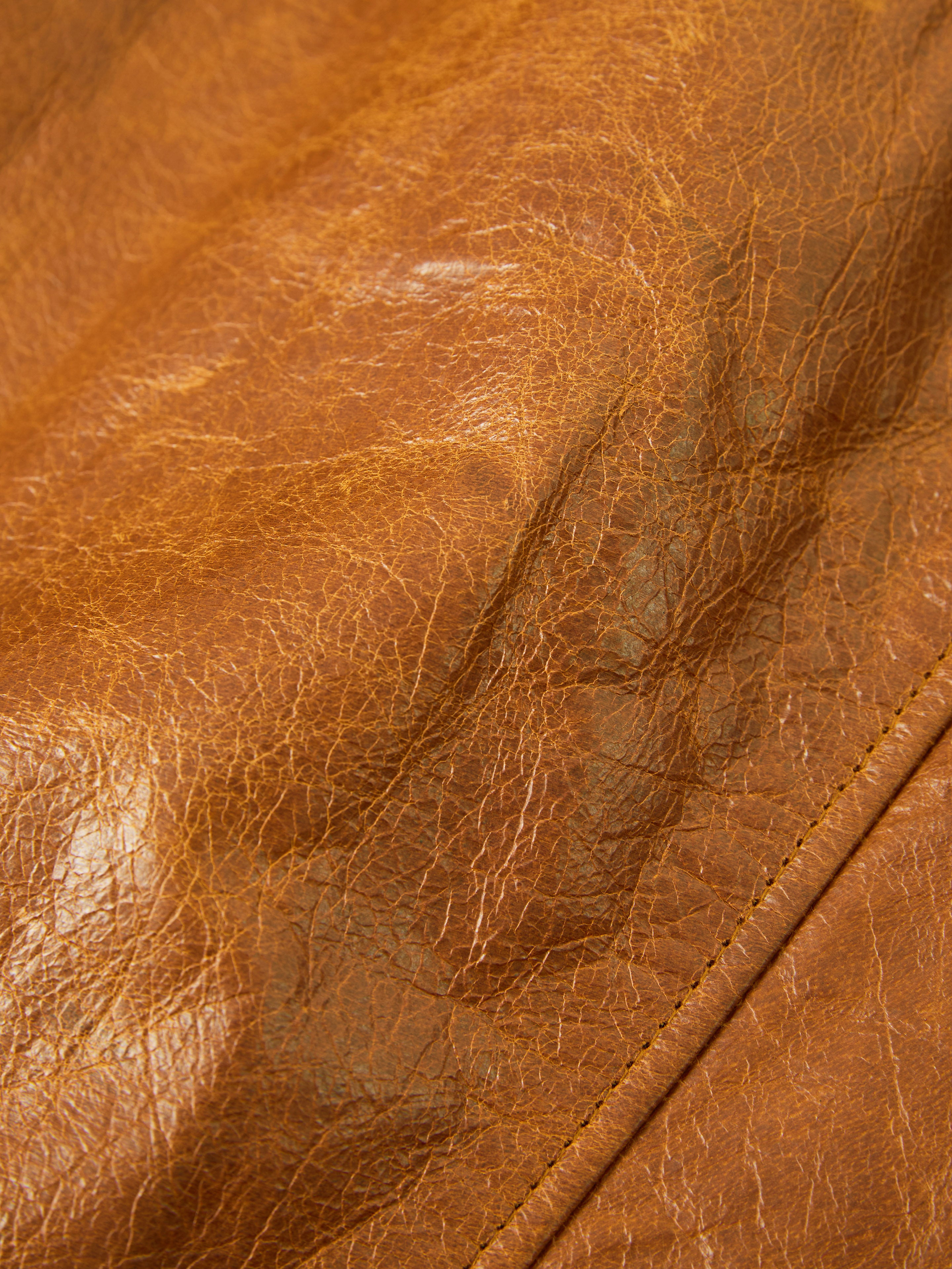 Close-up of FOUND's Marlboro Sun Faded Leather Racer Jacket, featuring distressed leather with visible creases and stitching, perfect for crafting a stylish piece.