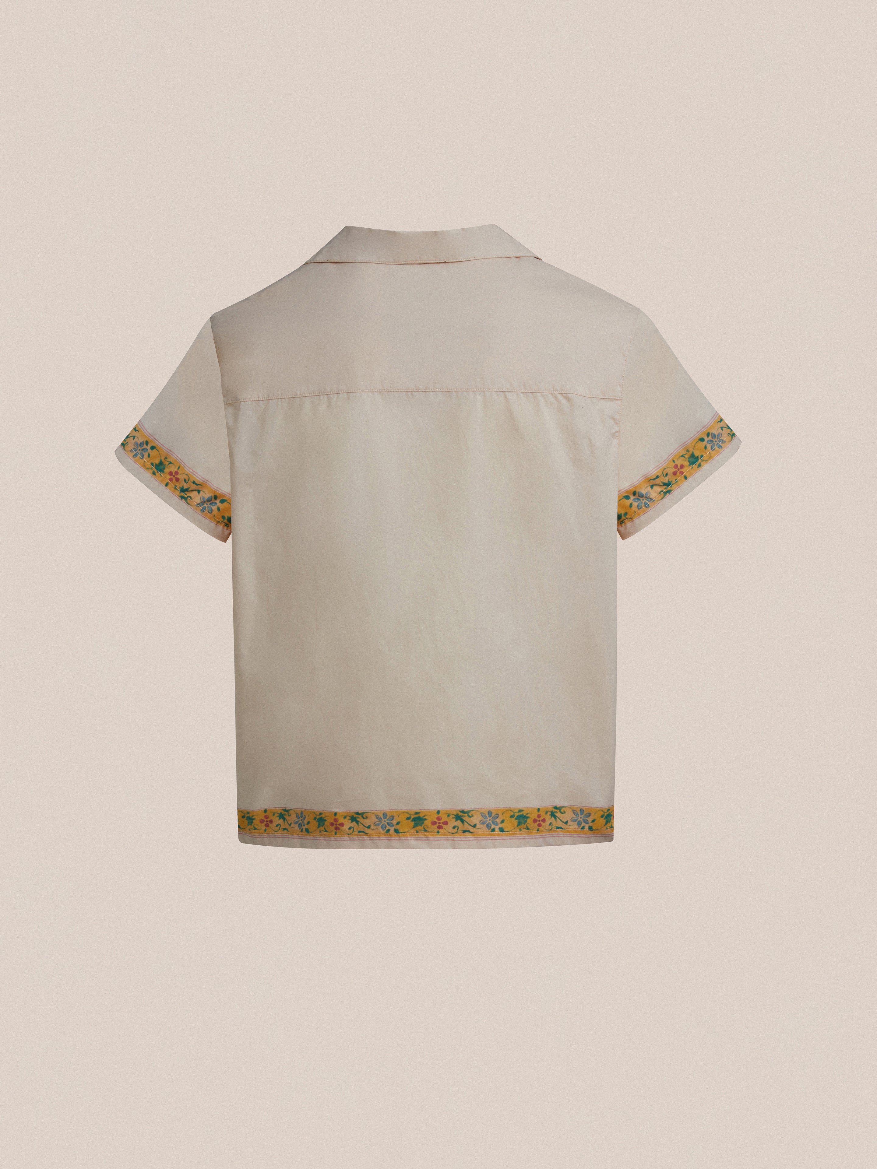 The back of a white Found Moth Camp Shirt with yellow trim.