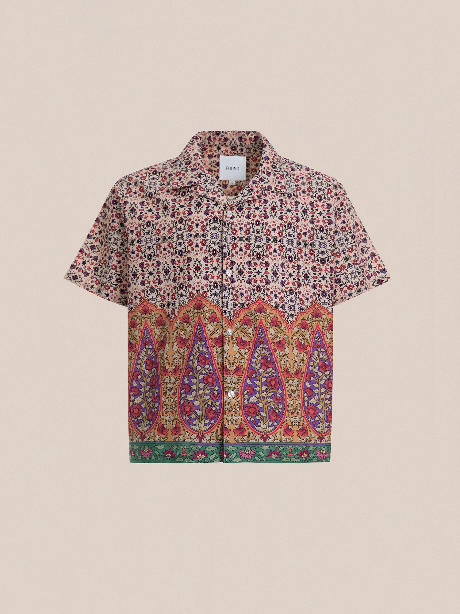 Profound Mughal Camp Shirt features a short-sleeved design with a multicolored floral and paisley pattern, showcasing a button-down front. The top half displays small flowers, while the bottom half boasts traditional Indo patterns and large paisley designs with green trim. It's made from 100% cotton fabric.