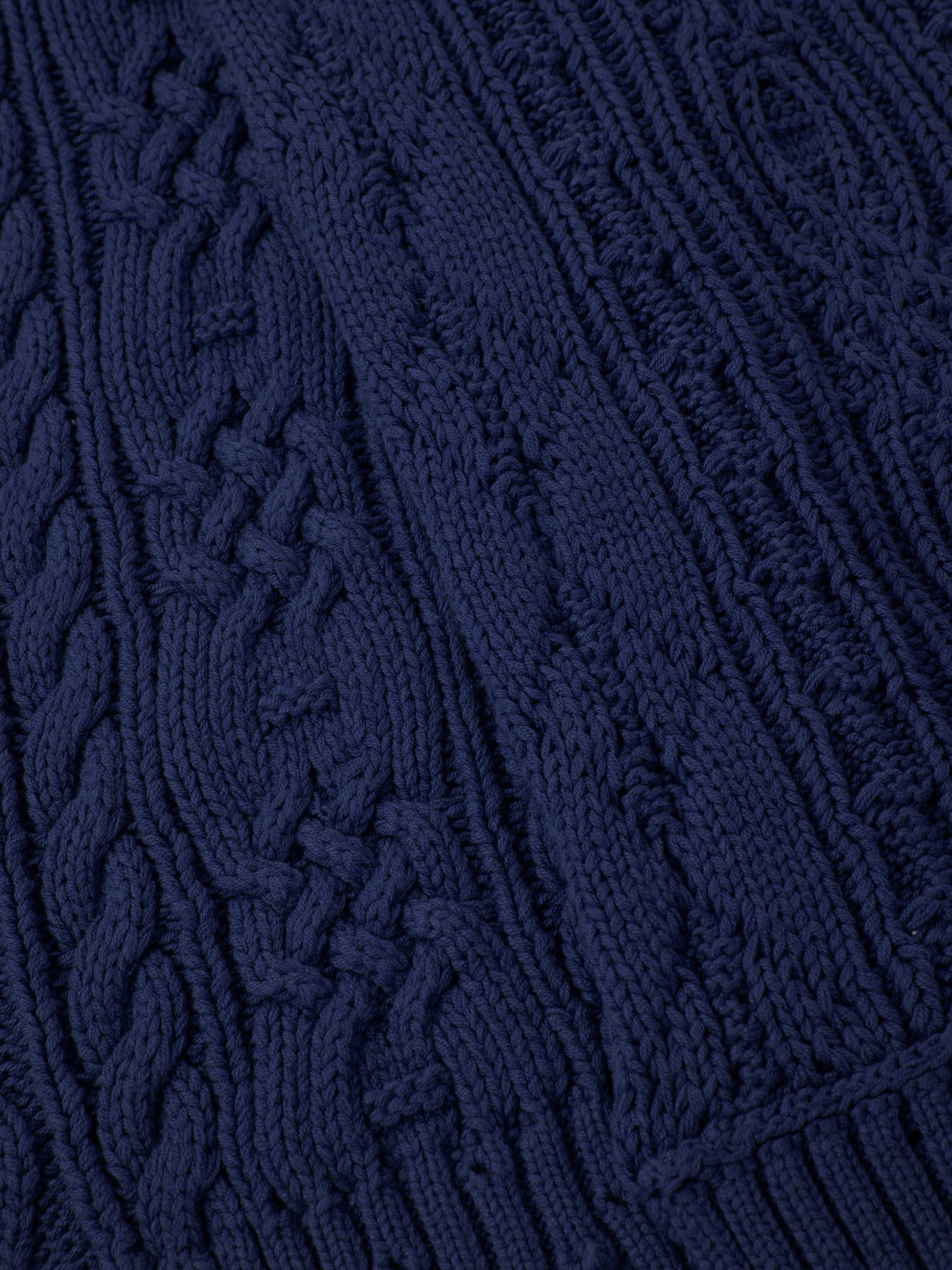 Close-up of the Navy Distressed Cable Knit Scarf by FOUND, showcasing various intricate cable knit patterns.