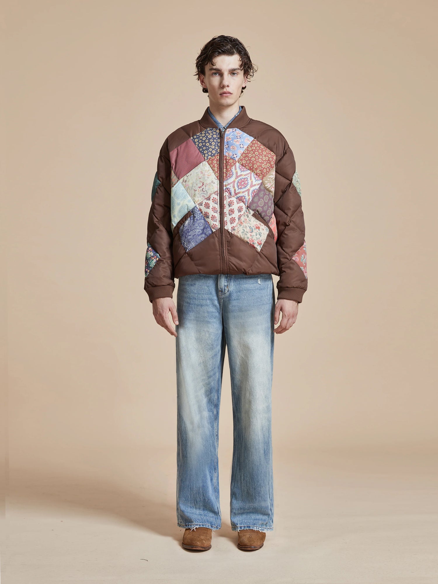 A man wearing a Found Diamond Quilt Patchwork Jacket and jeans.