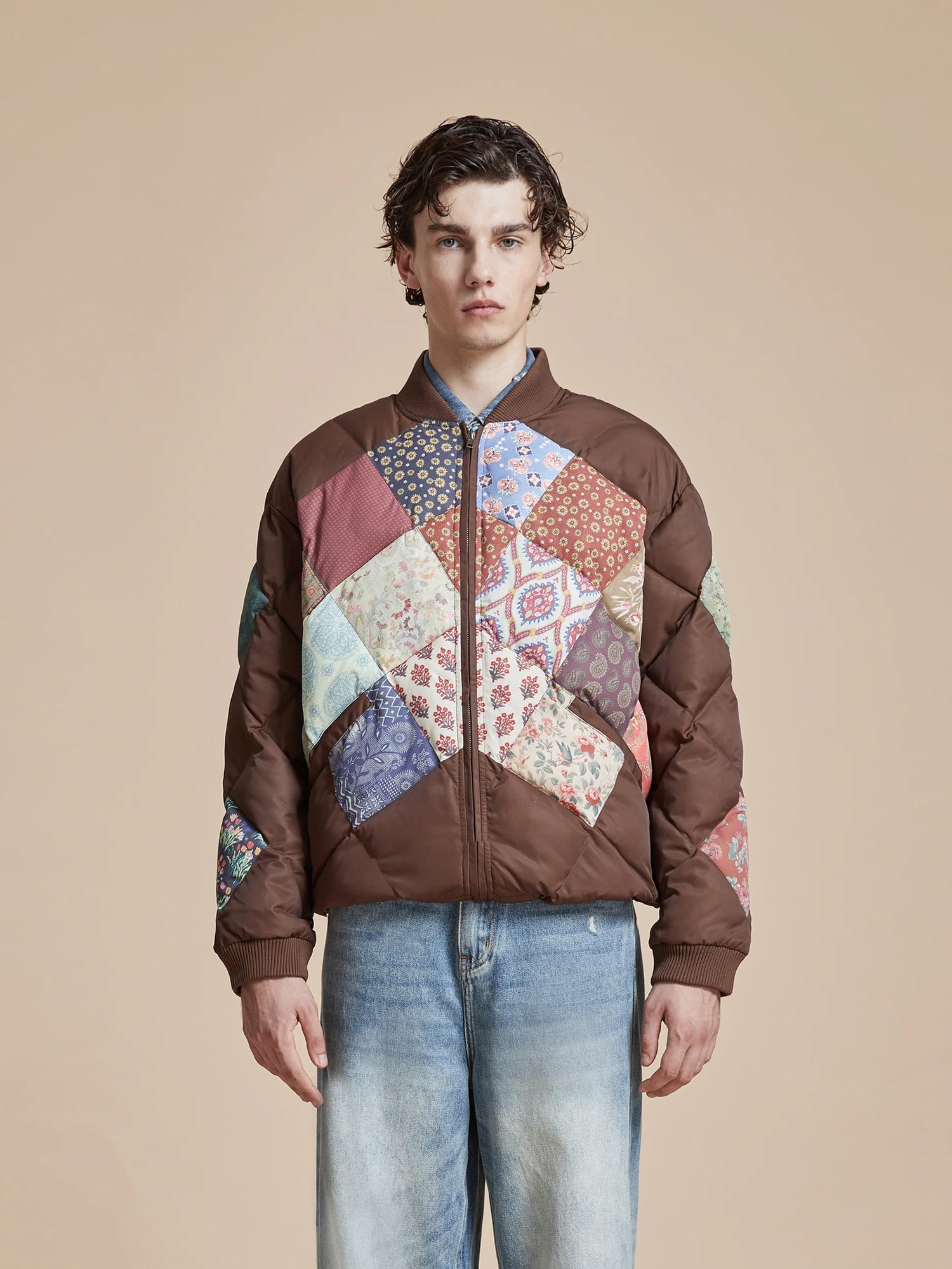 A man wearing a Found Diamond Quilt Patchwork Jacket and jeans.