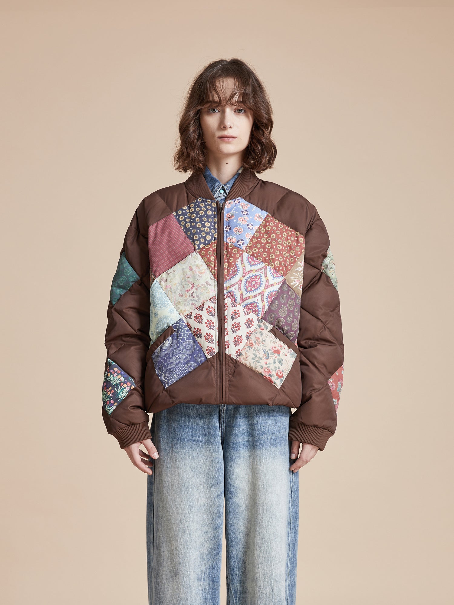 A woman wearing a Found Diamond Quilt Patchwork Jacket and jeans.