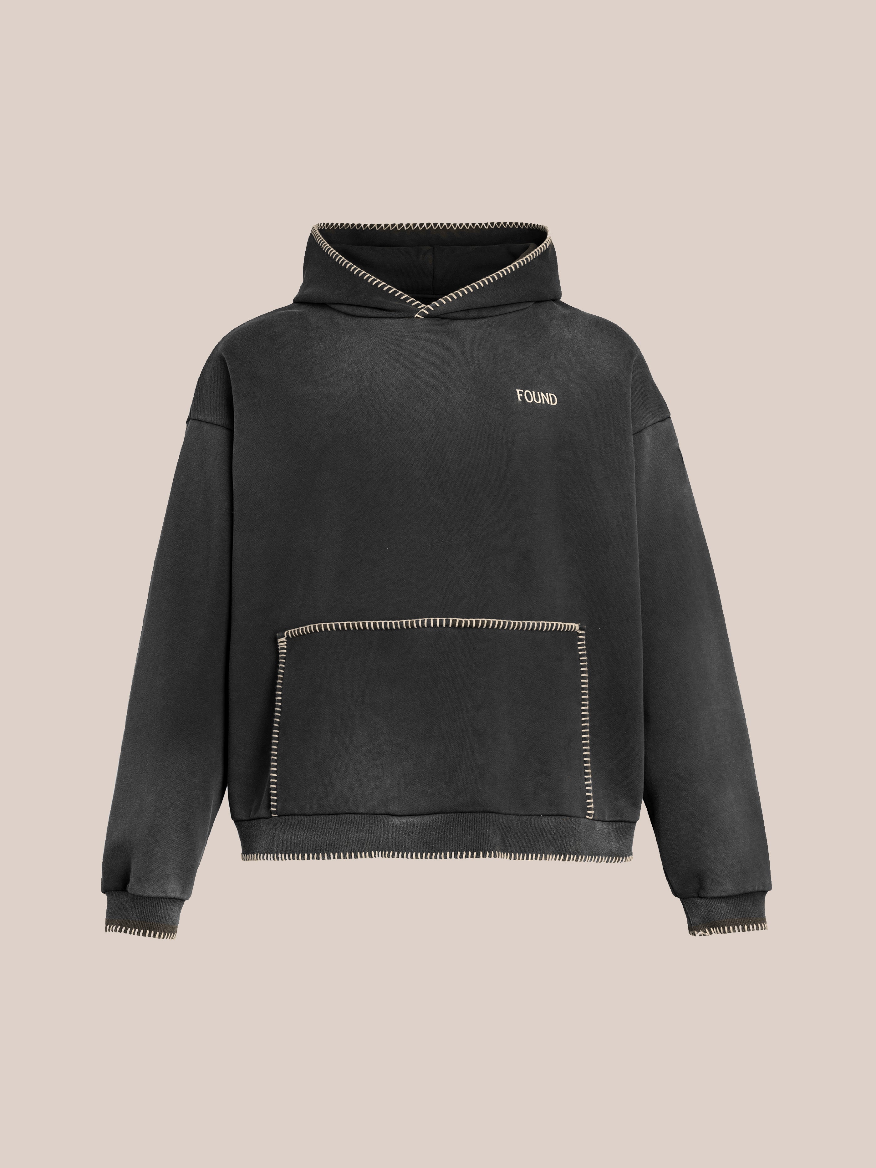 The Stitched Border Distressed Logo Hoodie by FOUND is a vintage black hoodie made from soft French terry cotton, showcasing a distressed "FOUND" logo on the chest and decorative white stitching along the edges.